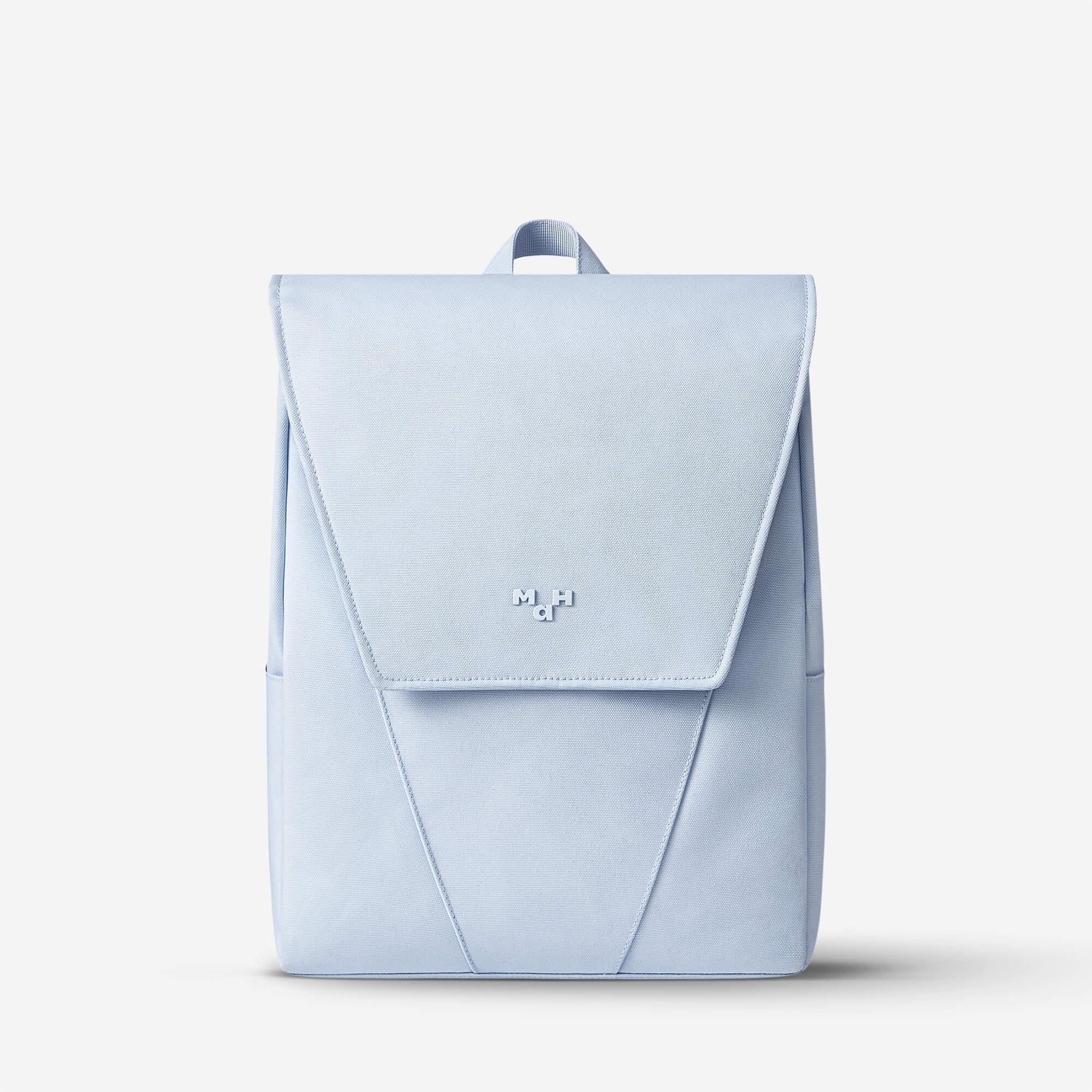 Light blue minimalist backpack with front flap and subtle logo, ideal for daily use or travel