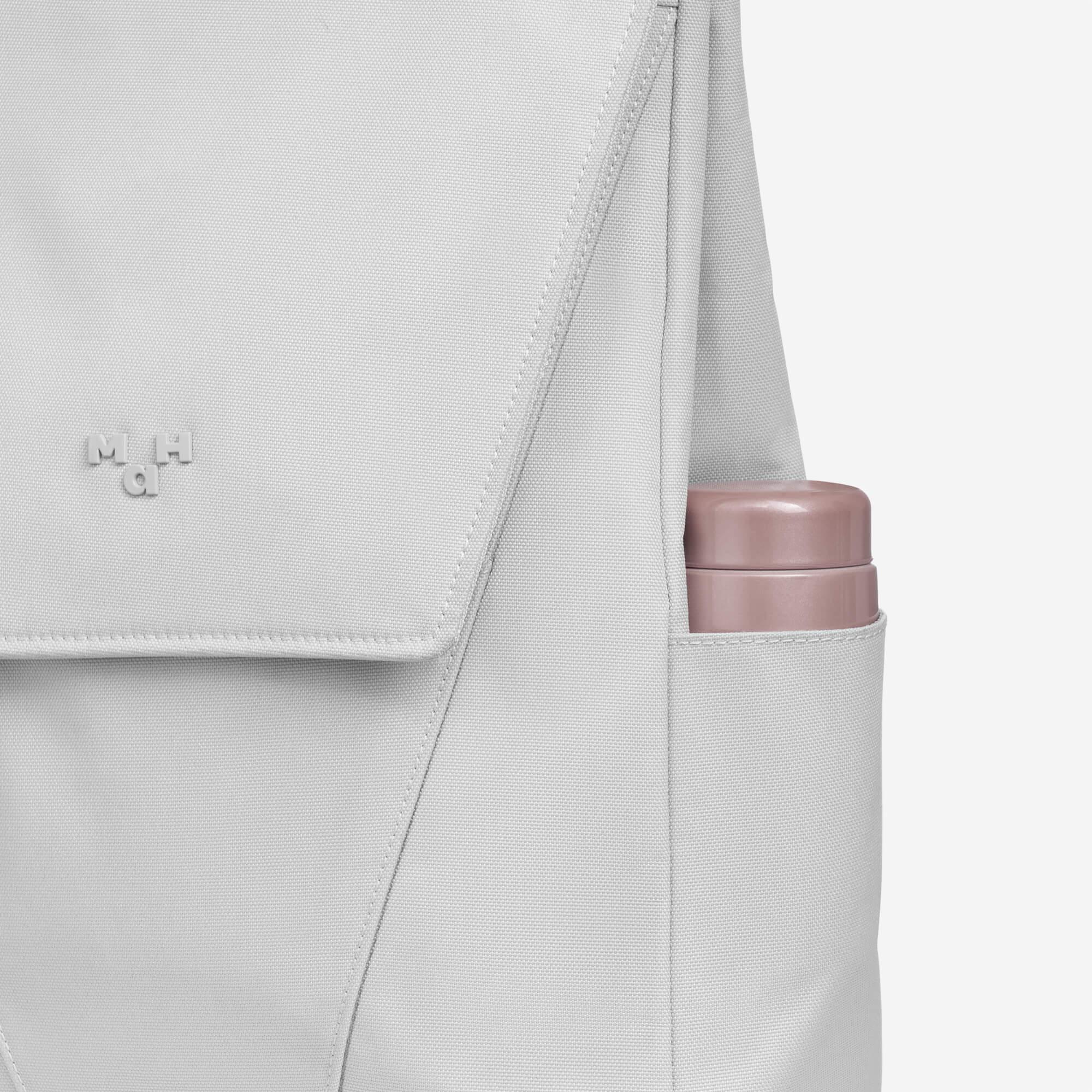 Light gray backpack with side water bottle pocket and subtle logo detail