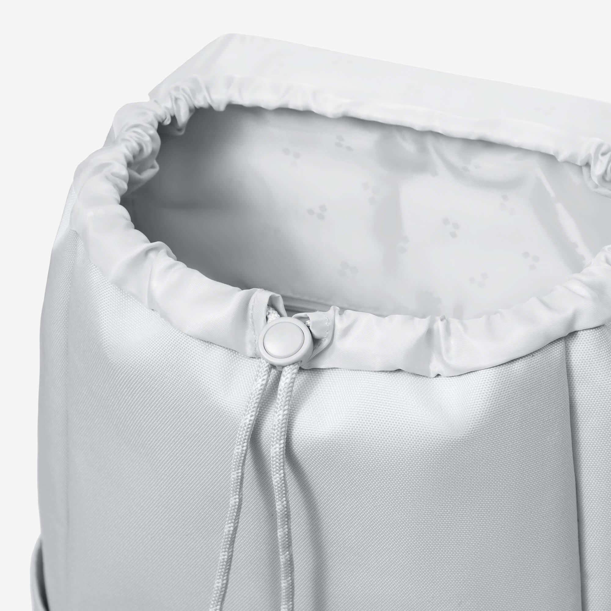 White drawstring backpack with adjustable closure and patterned interior lining