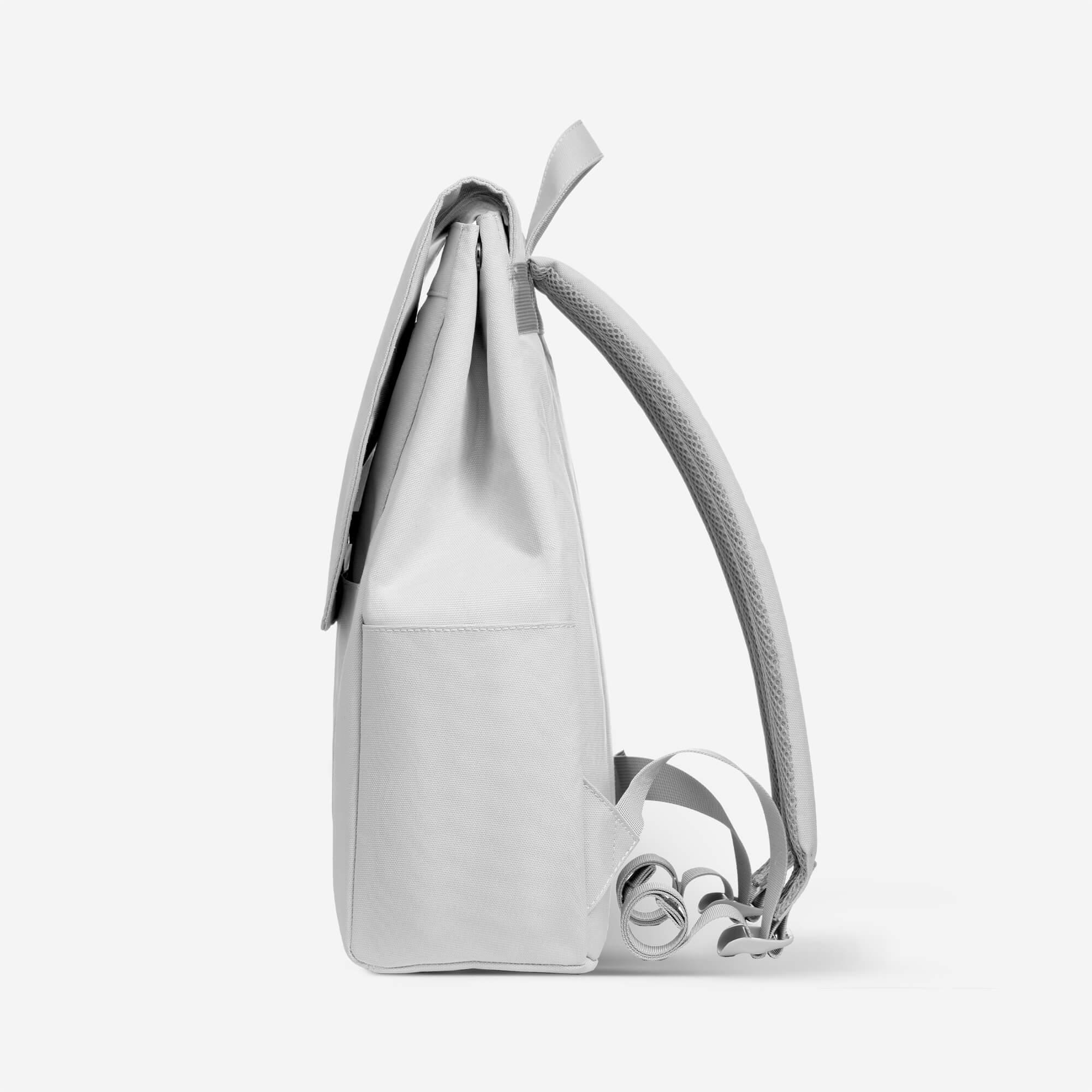 Light gray minimalist backpack with padded shoulder straps and side pocket, ideal for daily use or school.