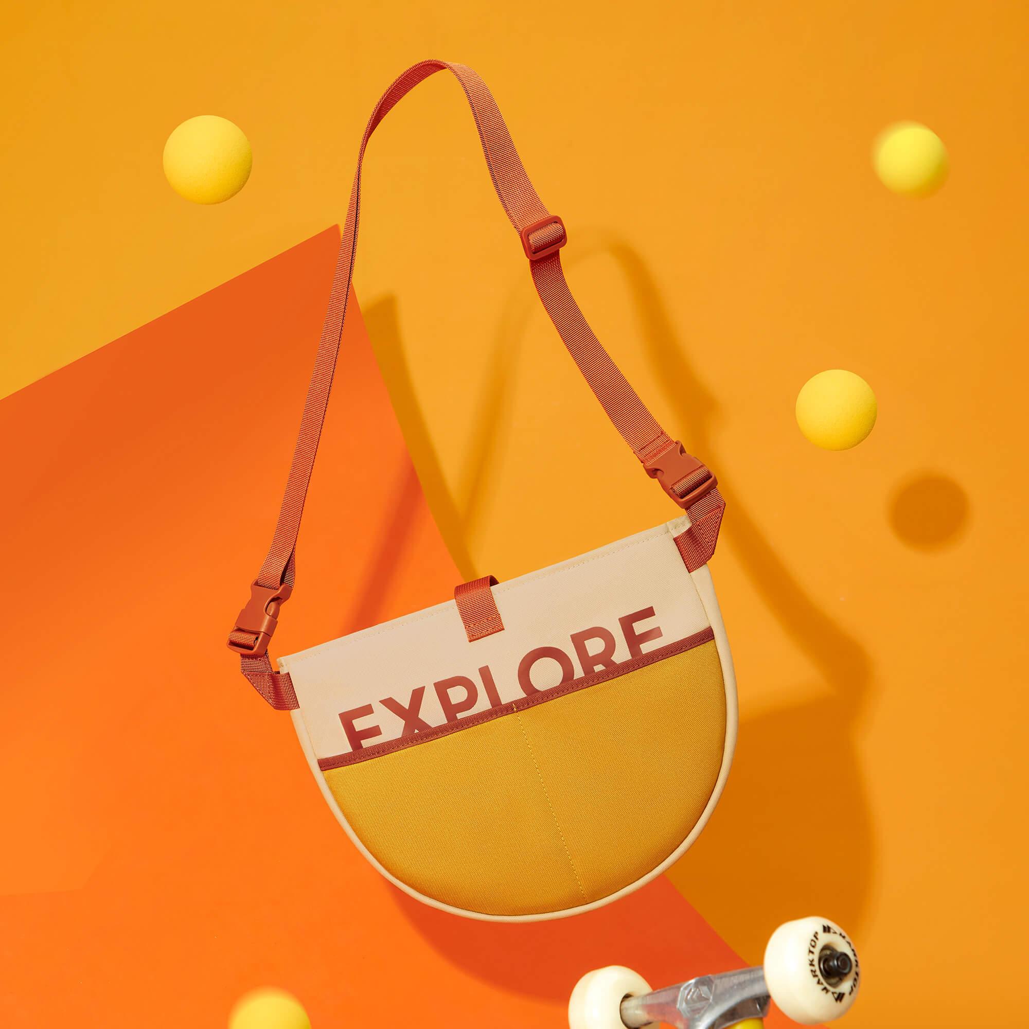 Explore print crossbody bag with adjustable strap, vibrant orange and yellow design, perfect for casual outings and adventures.