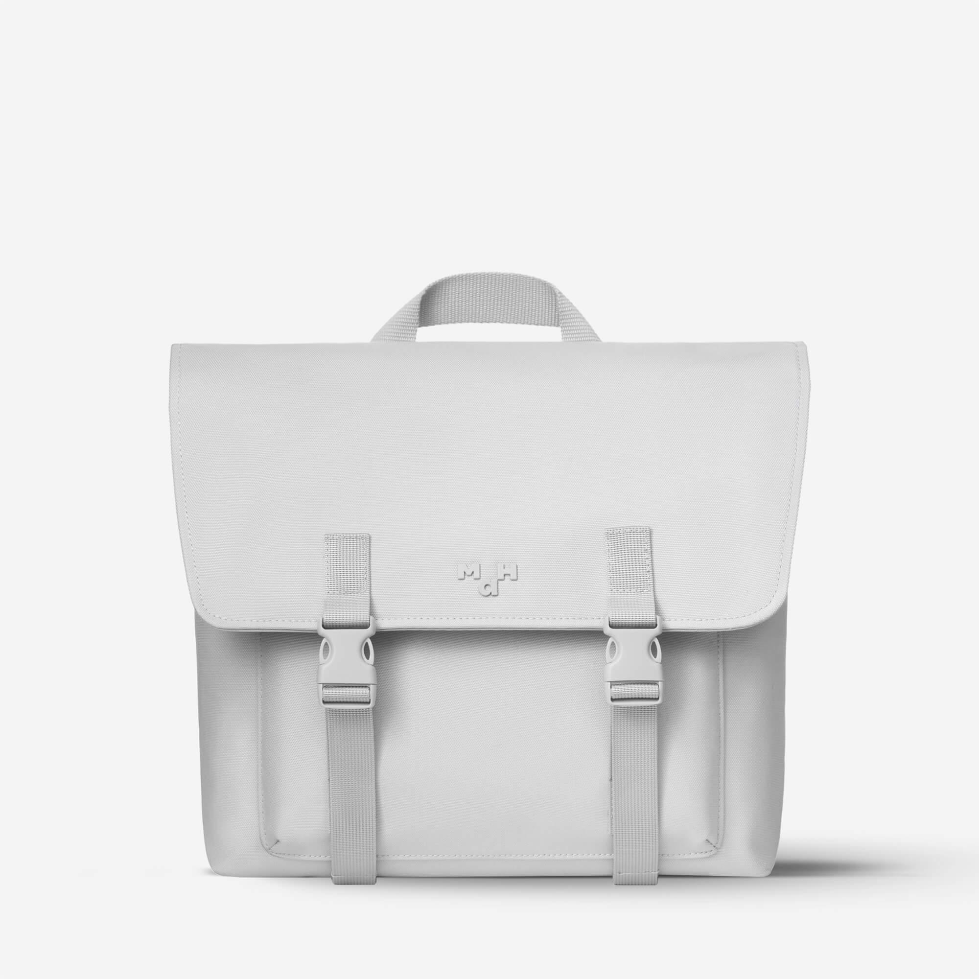 Minimalist light gray satchel bag with buckle straps and top handle, ideal for daily use or school