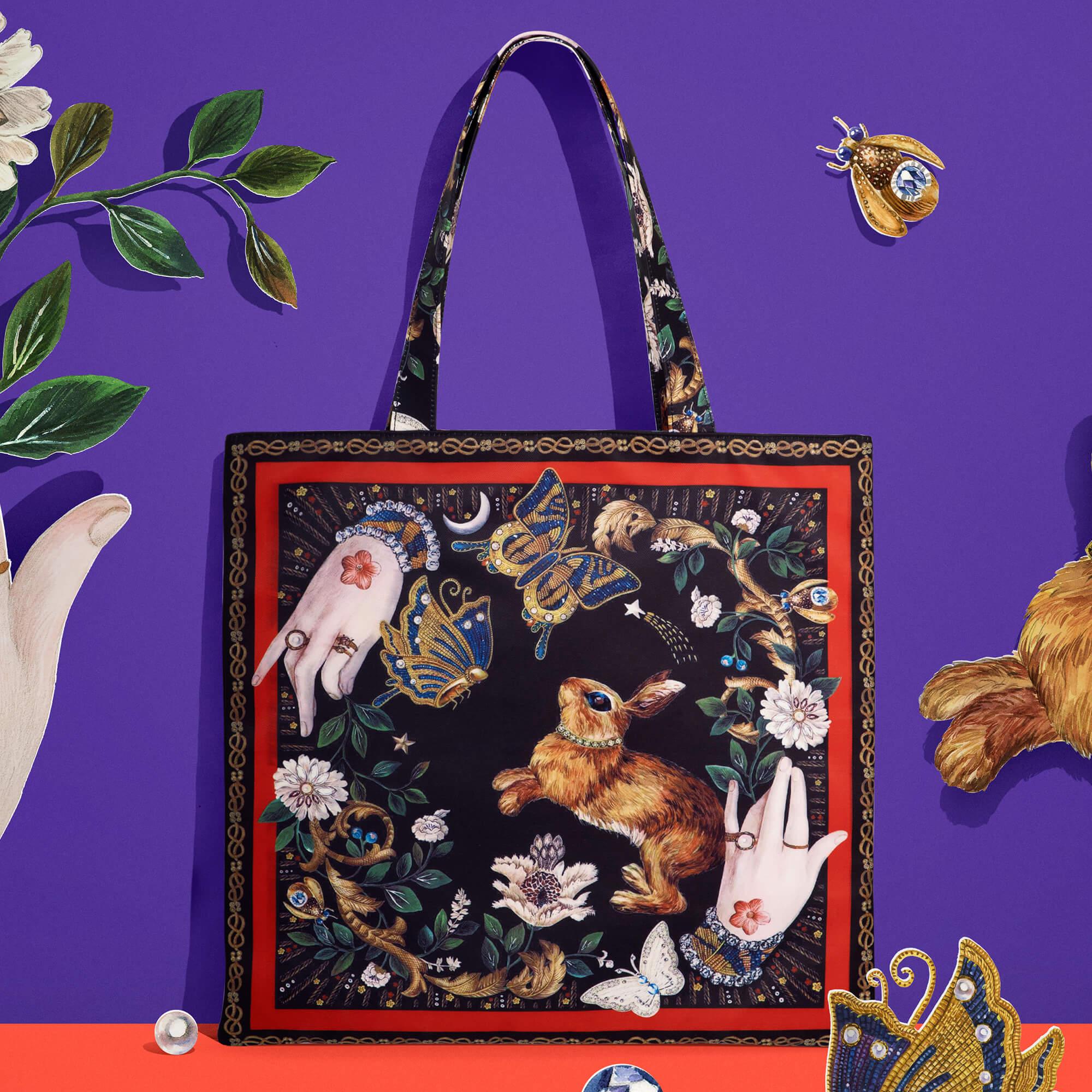 Artistic tote bag with rabbit, butterflies, and floral design on purple background