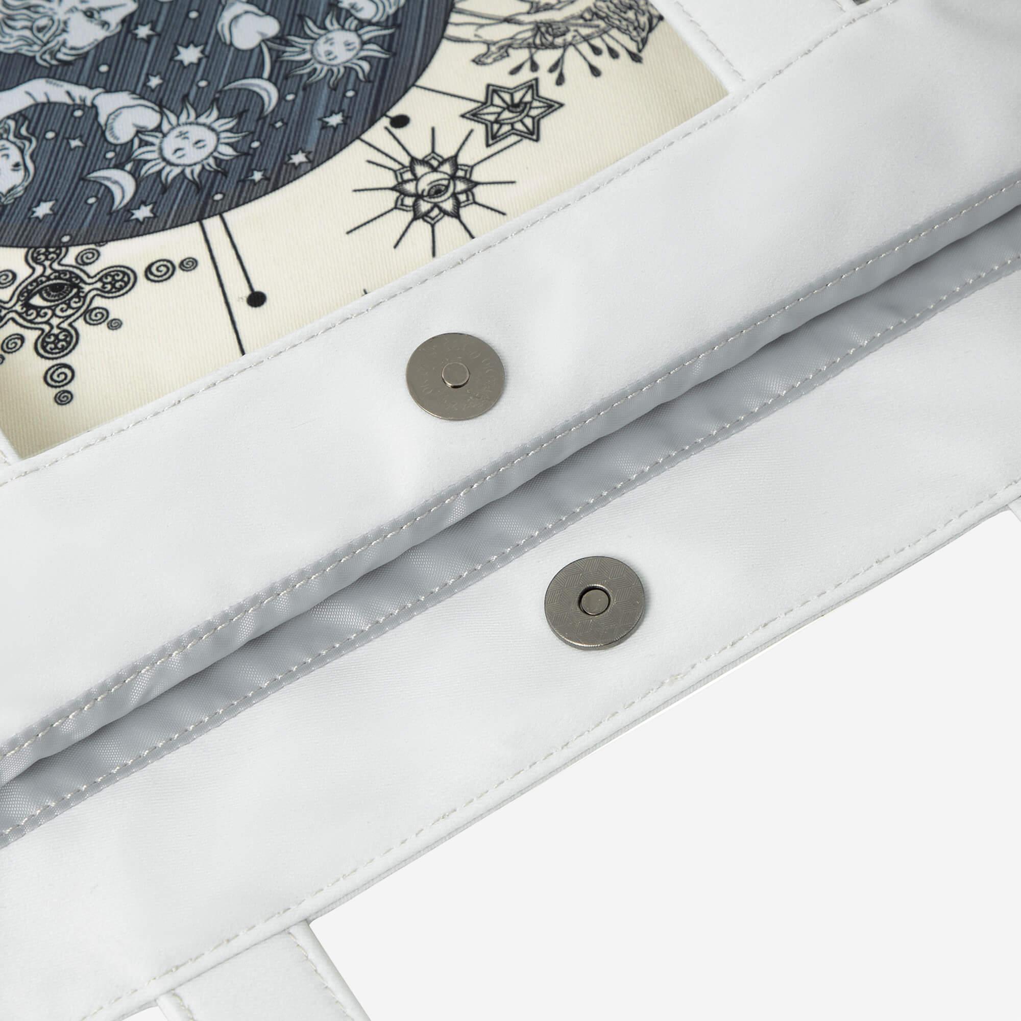 White bag with celestial print, sun moon stars, and metal snap closures
