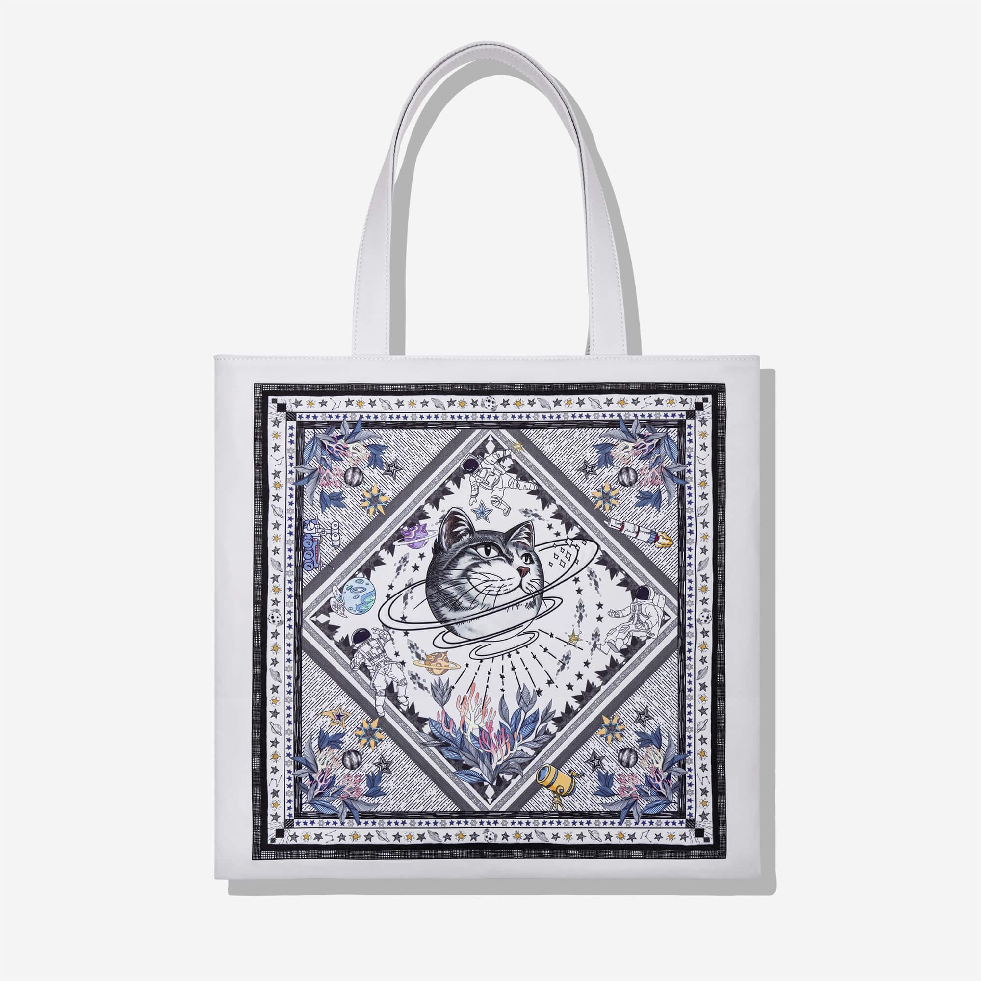 White tote bag with space cat print, astronauts, planets, and floral details for stylish everyday use