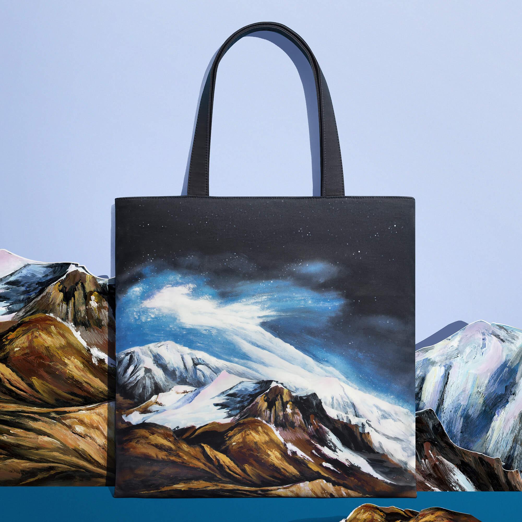 Tote bag with painted mountain landscape under starry sky, stylish accessory for everyday use