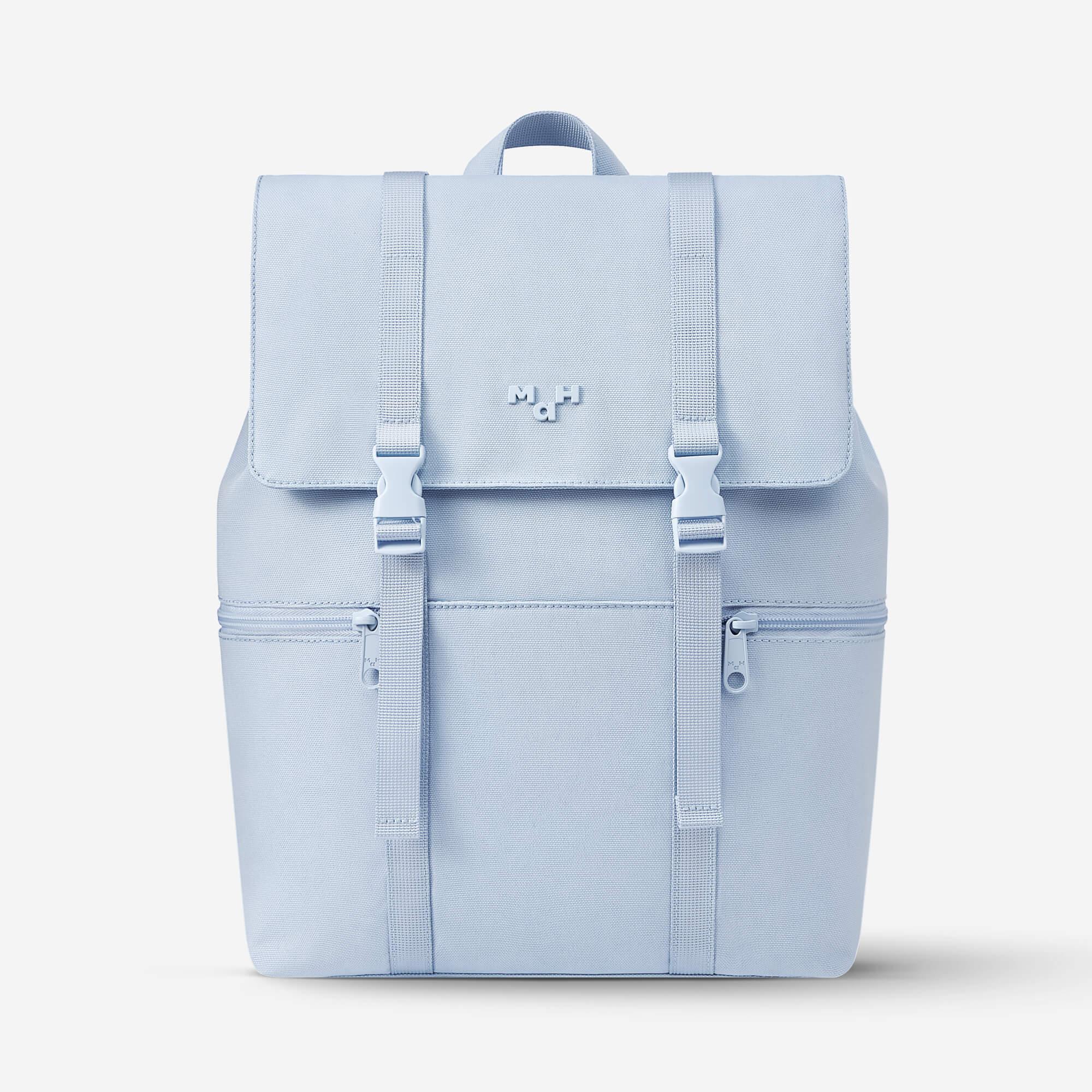Light blue minimalist backpack with front flap, buckles, and side pockets, ideal for daily use or school.