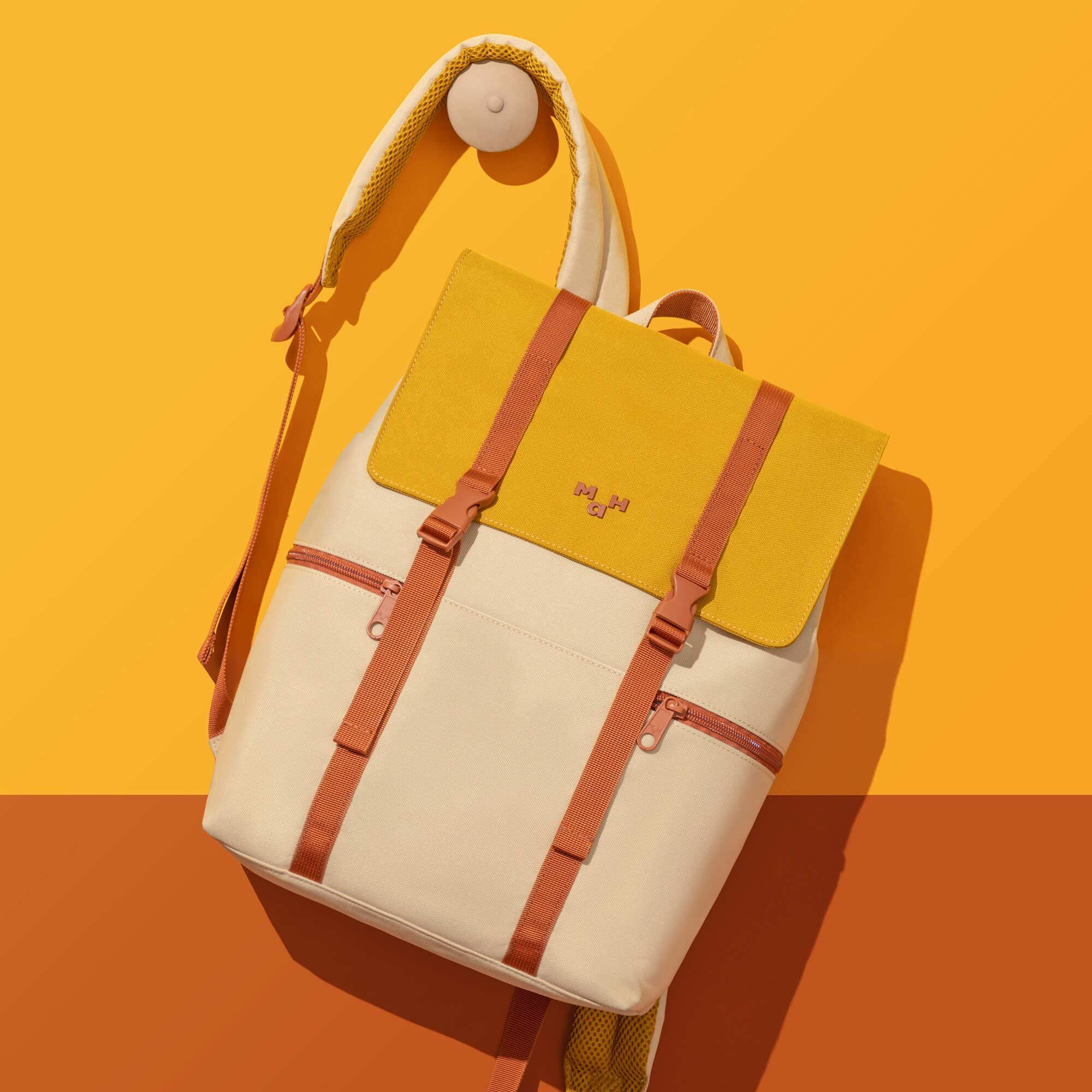 Stylish yellow and cream backpack with orange straps, perfect for everyday use or travel