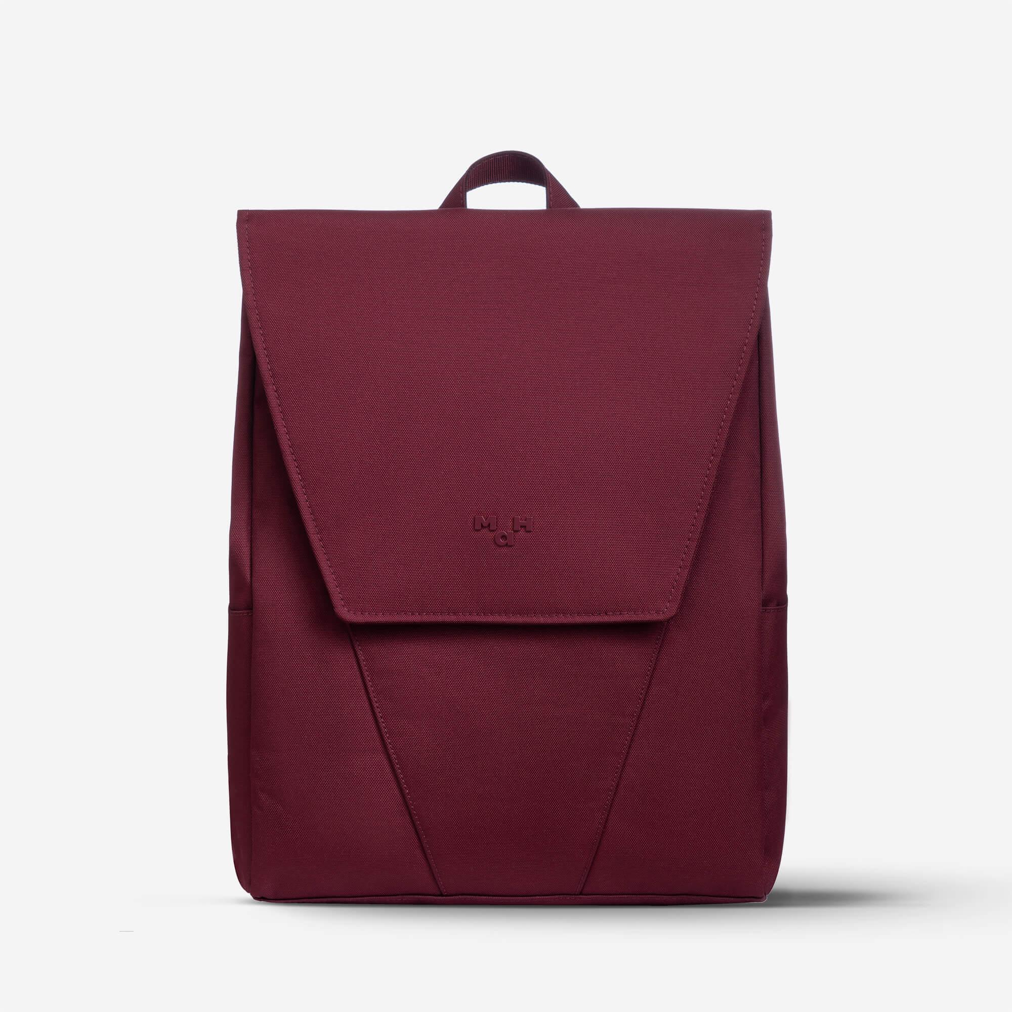 Burgundy minimalist backpack with flap closure and top handle, ideal for daily use or travel