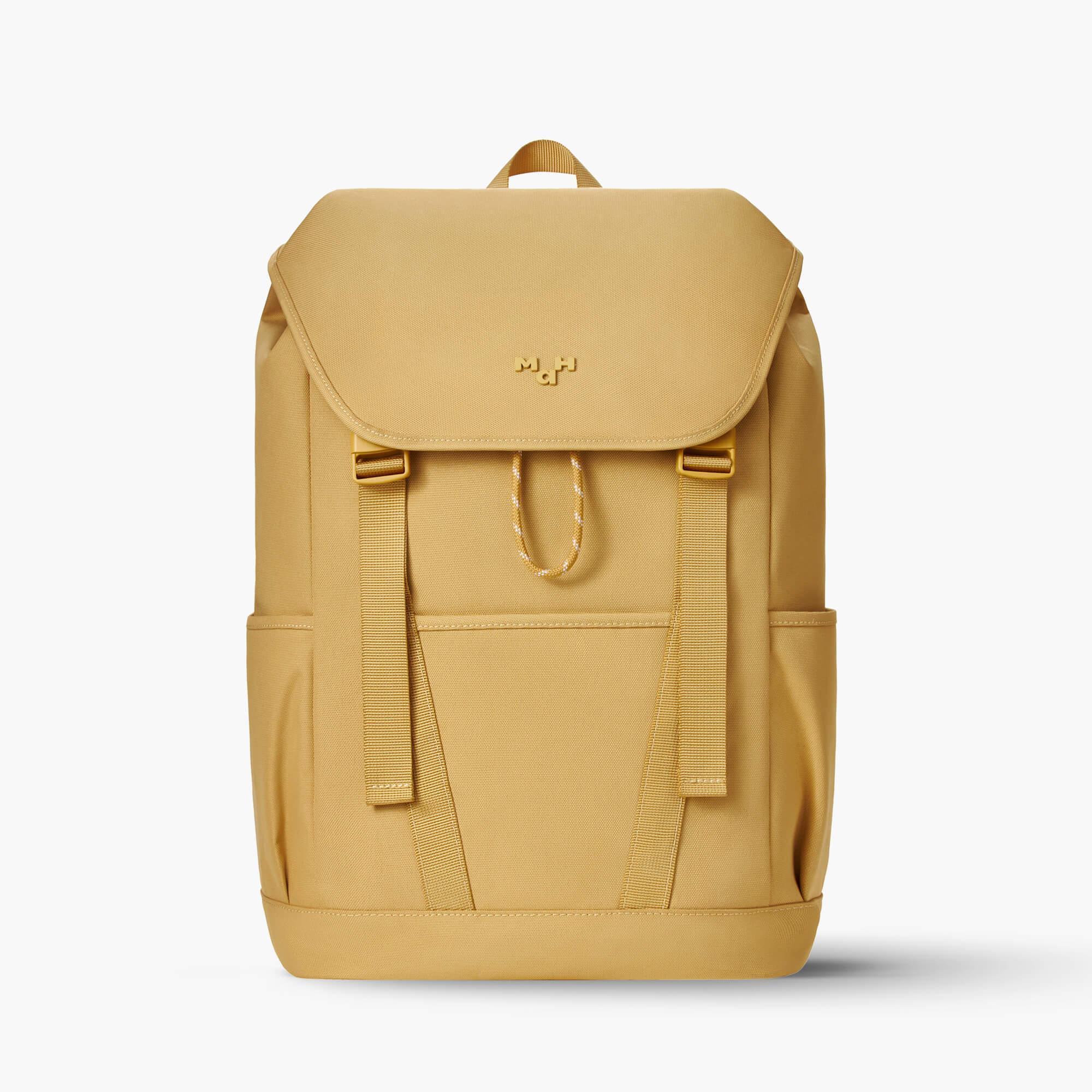 Mustard yellow backpack with front flap, side pockets, and drawstring closure, ideal for daily use or travel.