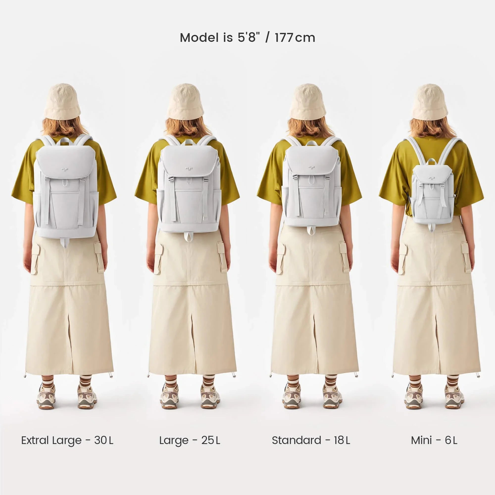 Four sizes of minimalist white backpacks shown on model: Extra Large 30L, Large 25L, Standard 18L, Mini 6L