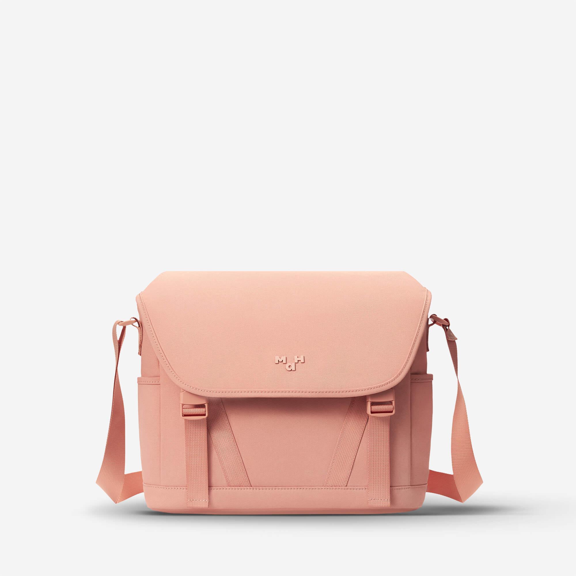 Pink canvas crossbody bag with adjustable strap and front flap closure, ideal for everyday use.
