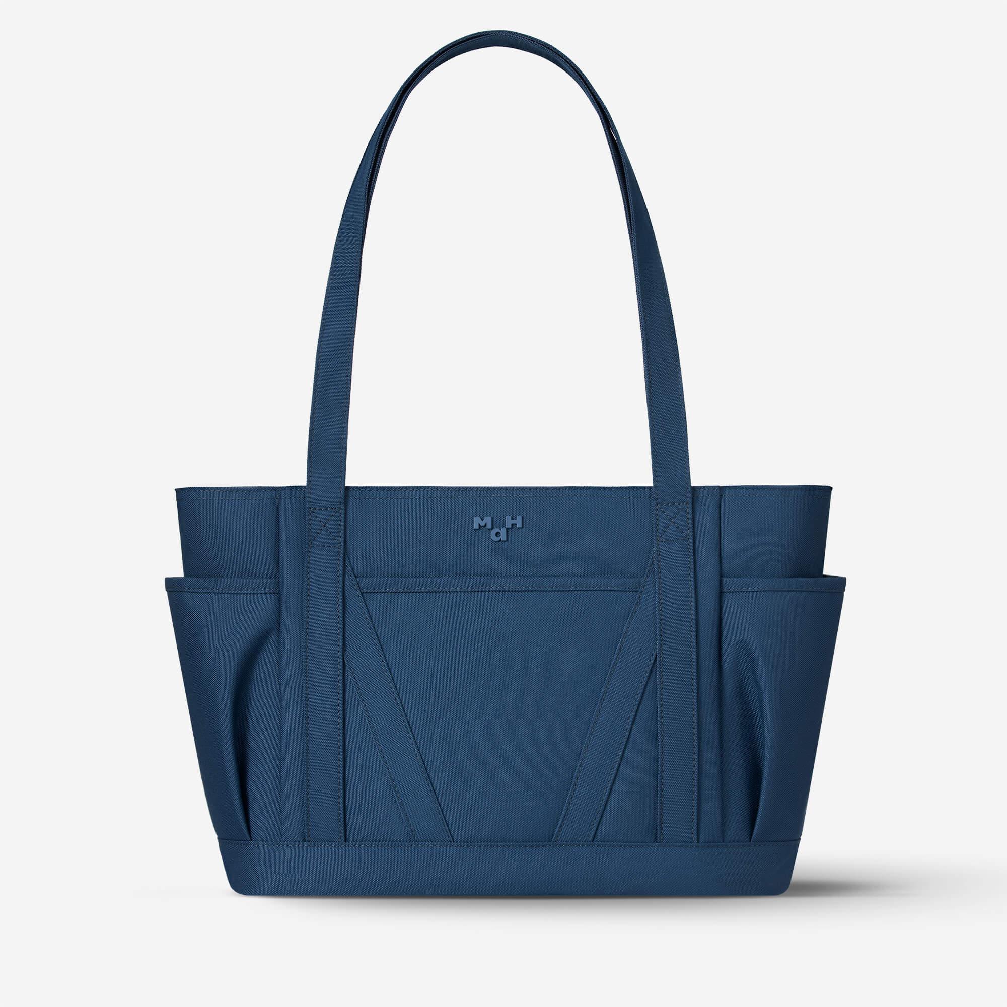 Navy blue tote bag with side pockets and minimalist design, ideal for everyday use and travel.