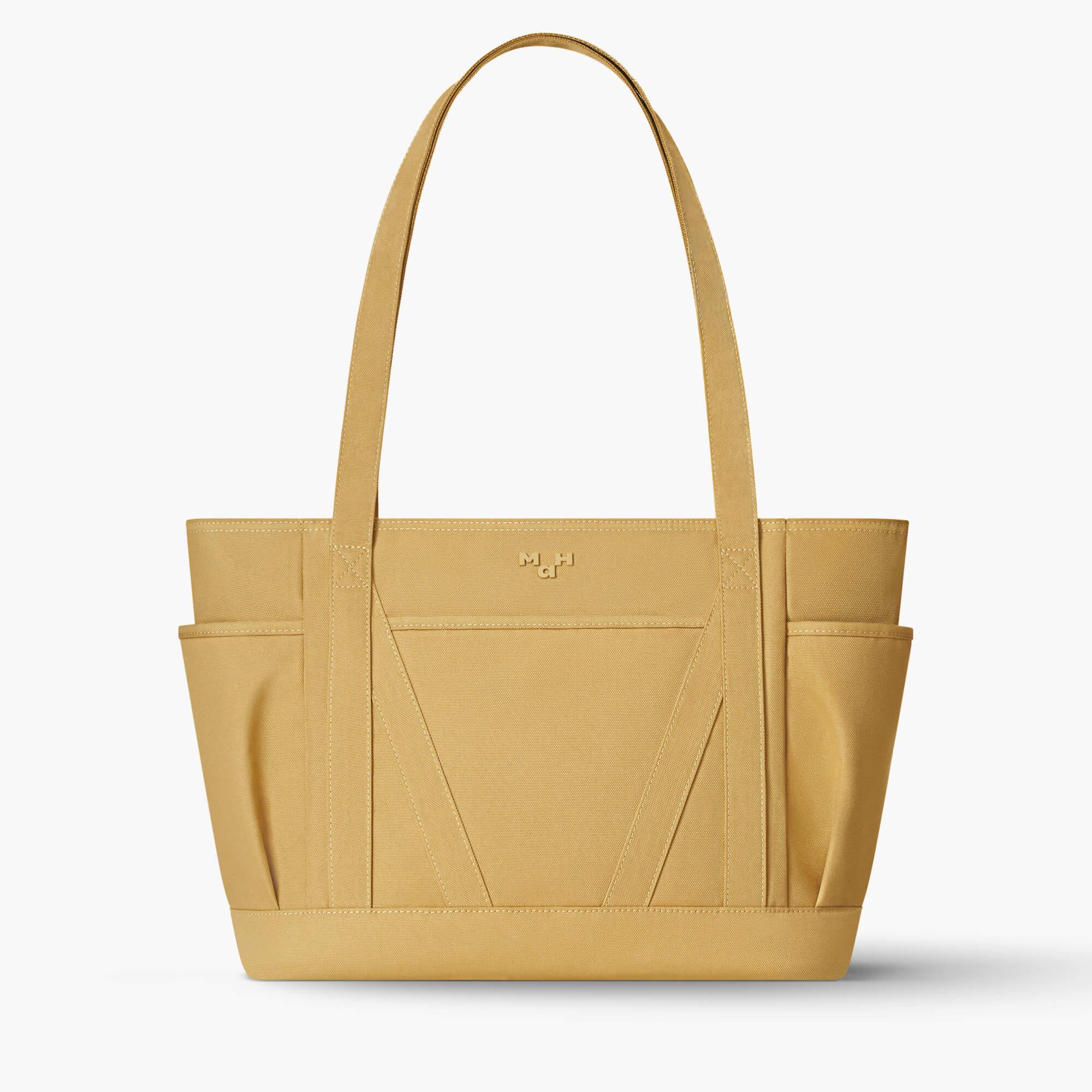 Mustard yellow canvas tote bag with side pockets and minimalist design, ideal for everyday carry.