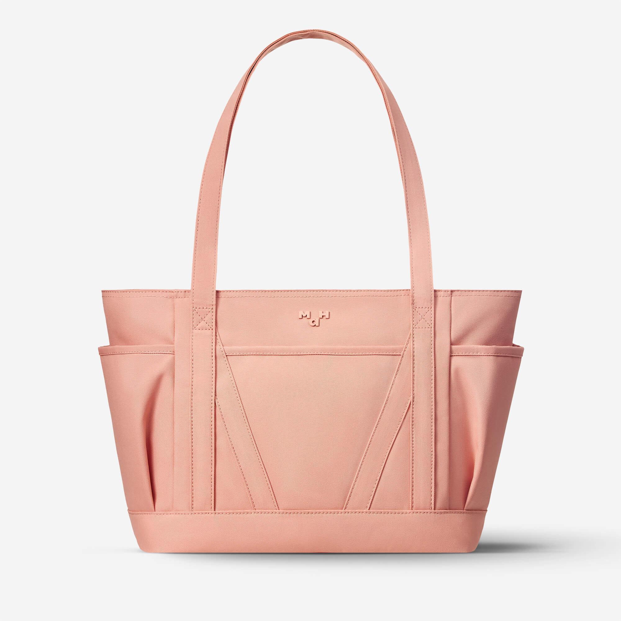 Pink canvas tote bag with side pockets and top handle, ideal for everyday carry and lifestyle use.