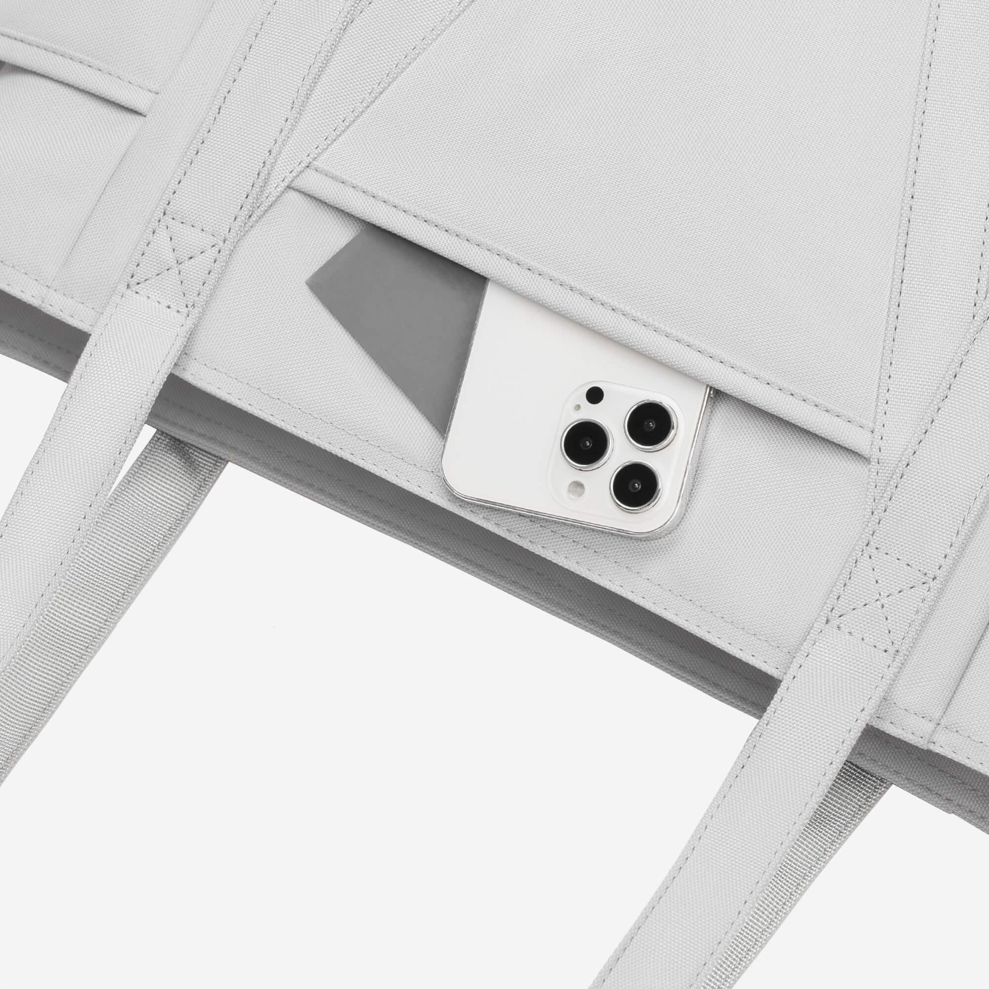 Light gray backpack with phone pocket, showcasing sleek design and secure storage for daily essentials.