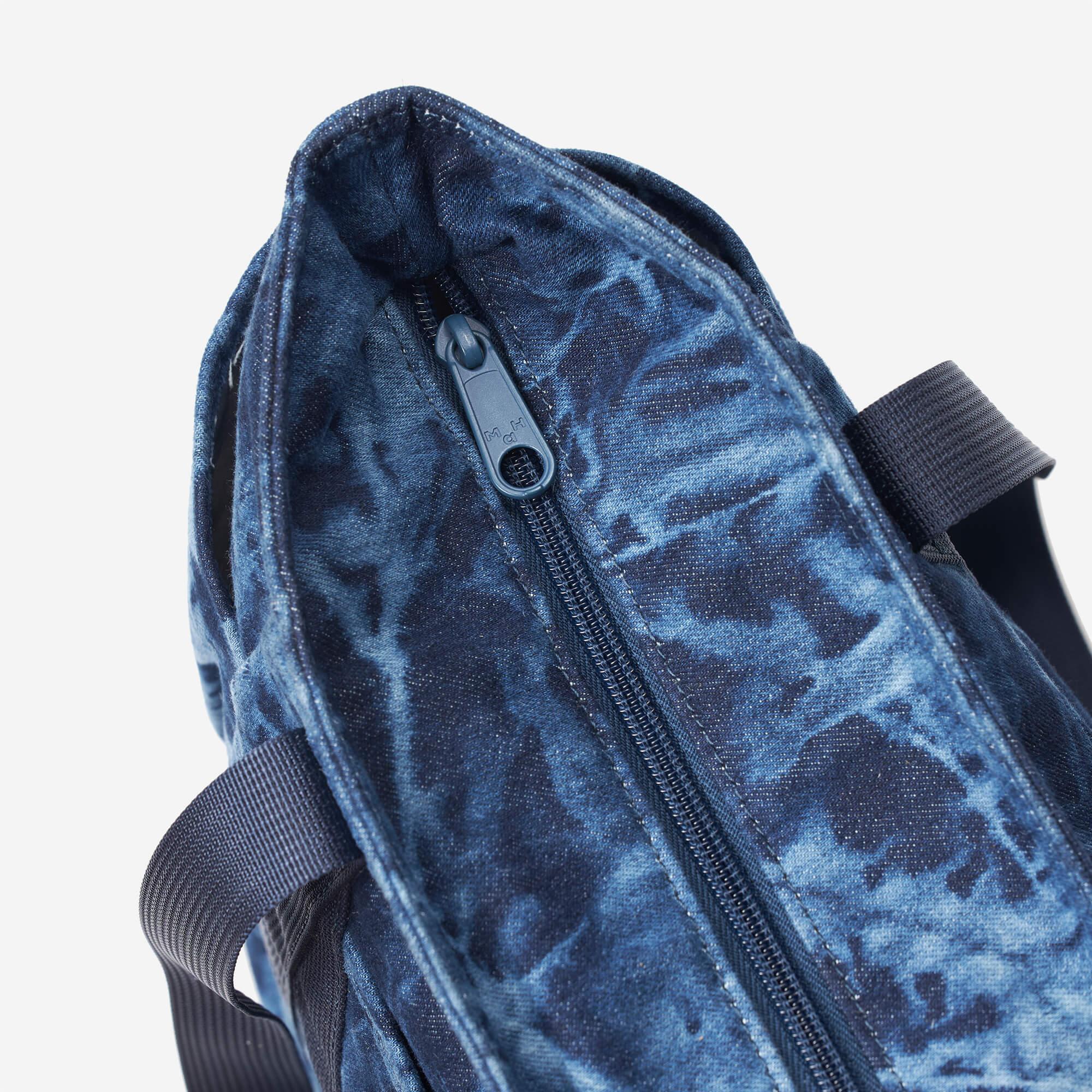 Blue tie-dye backpack with zipper detail and durable straps, ideal for everyday use and travel.