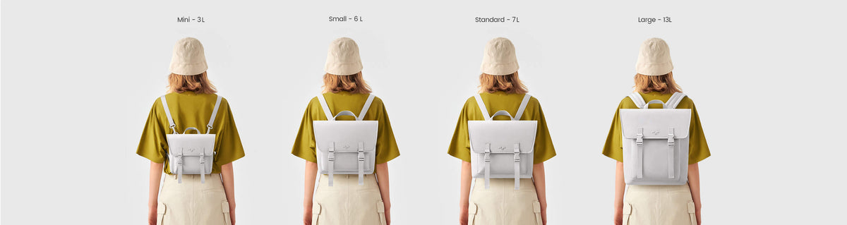 Four sizes of minimalist white backpacks: Large 13L, Standard 7L, Small 6L, Mini 3L, worn by model in olive tee and beige skirt.