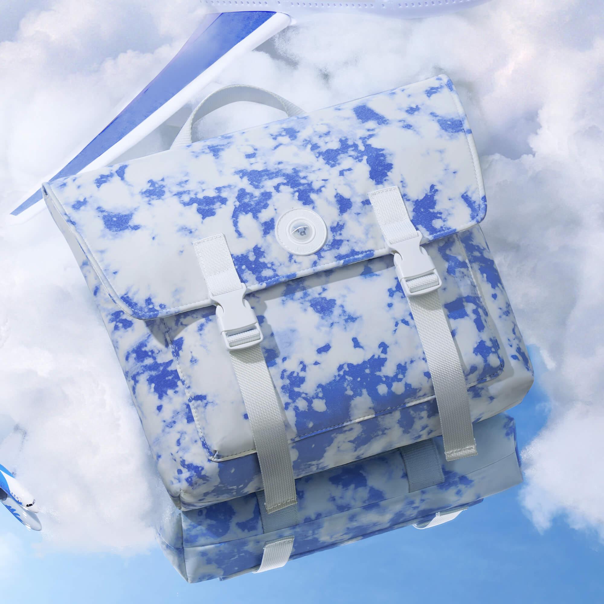 Blue and white cloud-print backpack with airplane, ideal for travel and everyday use.
