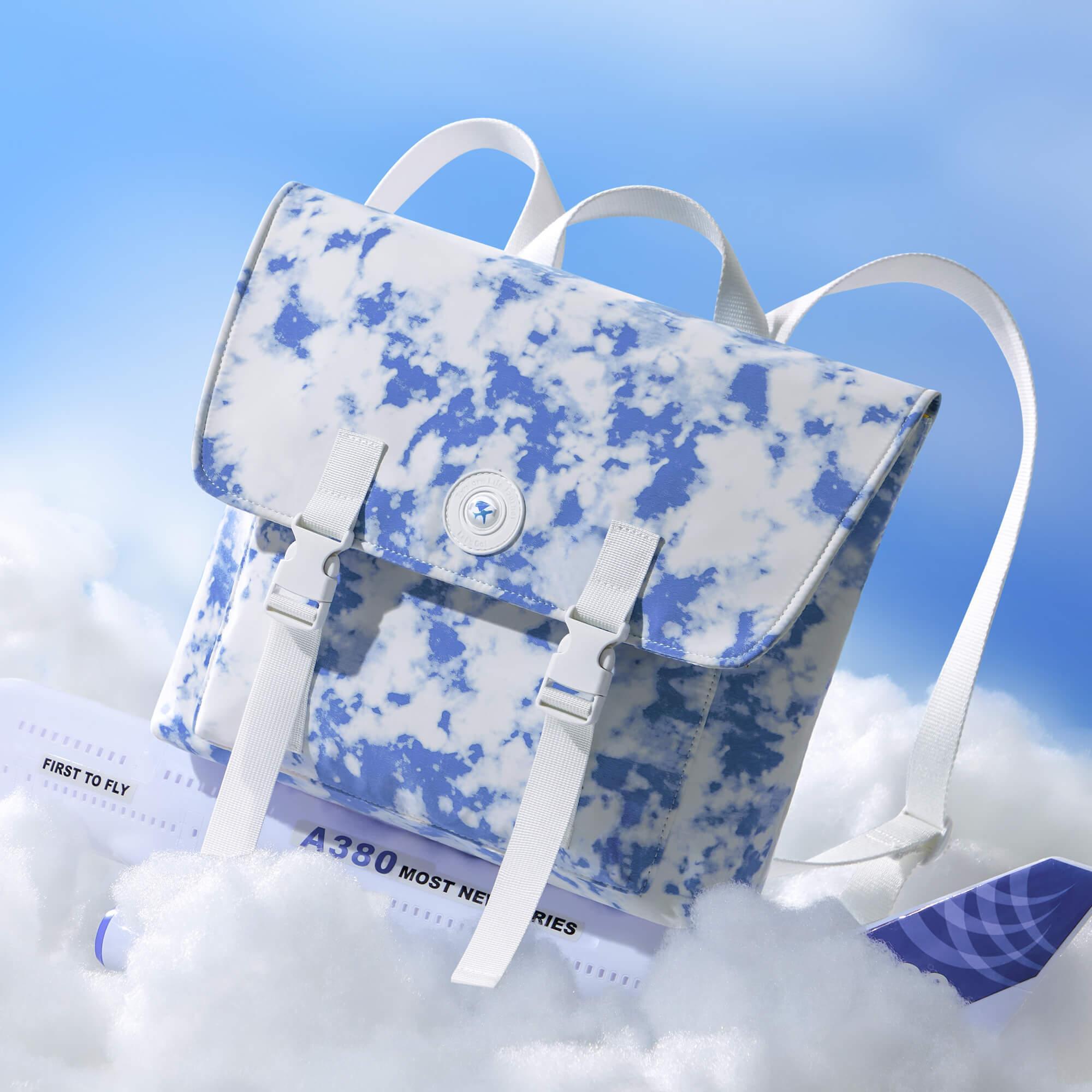 Blue and white cloud print backpack with airplane model, ideal for travel and everyday use.