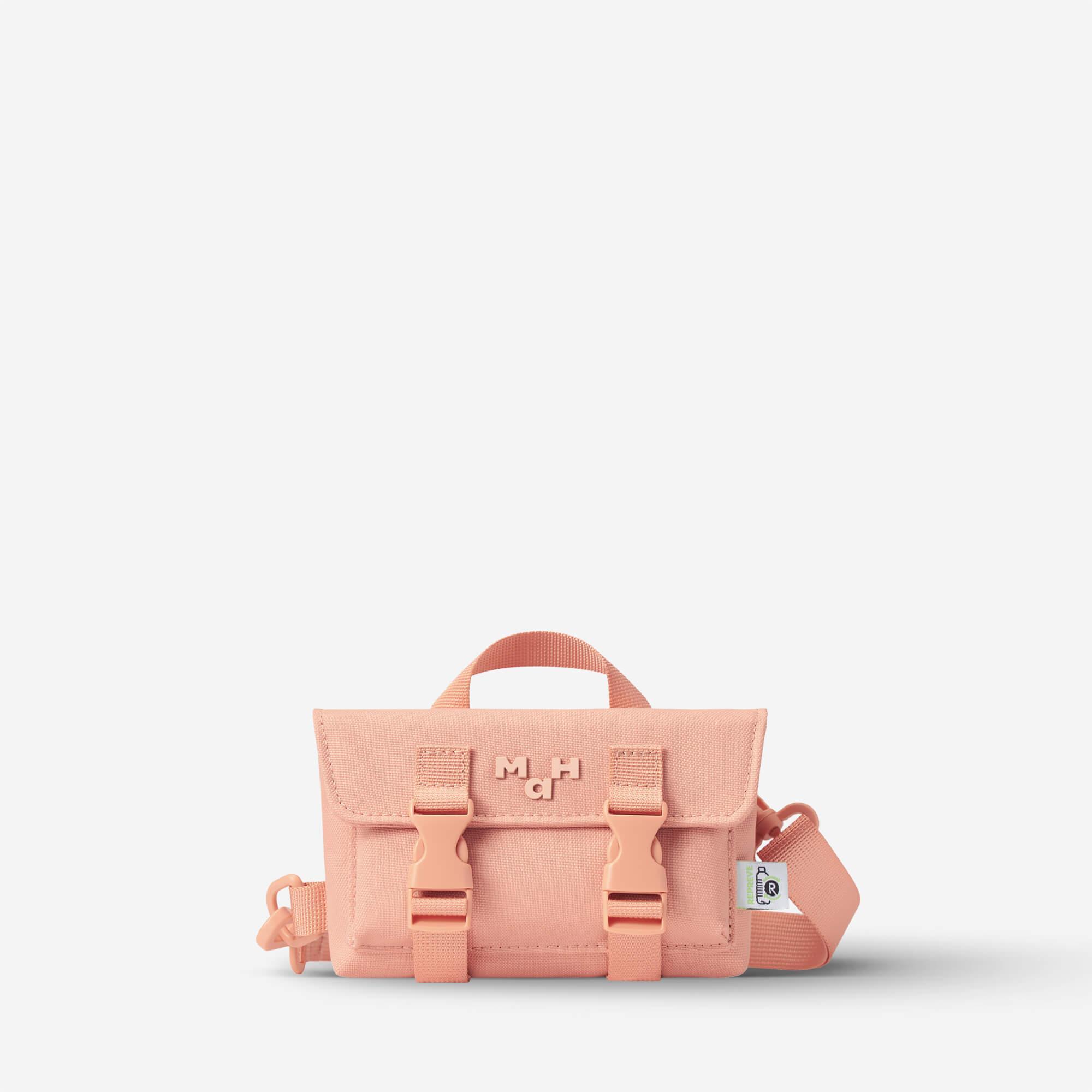 Pink mini crossbody bag with buckle straps and top handle, stylish everyday accessory