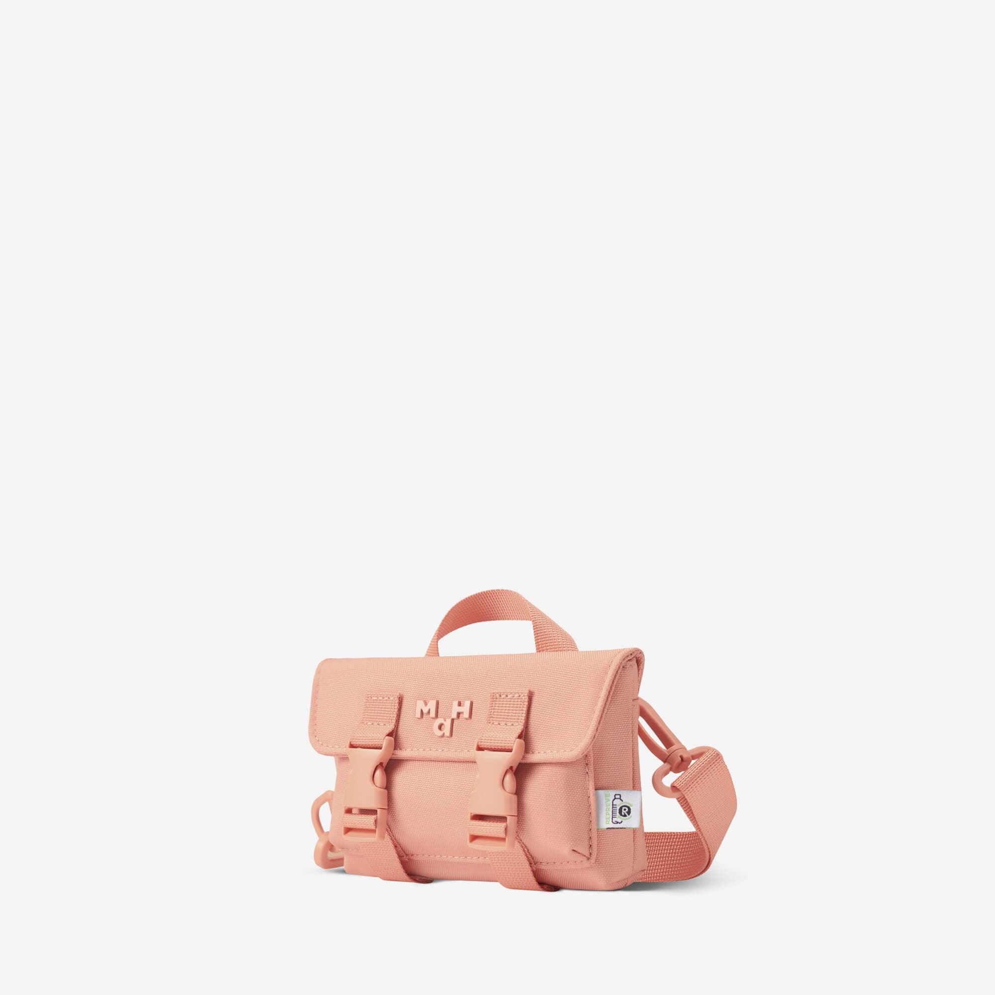 Pink mini crossbody bag with buckle straps and top handle, ideal for everyday carry and lifestyle use