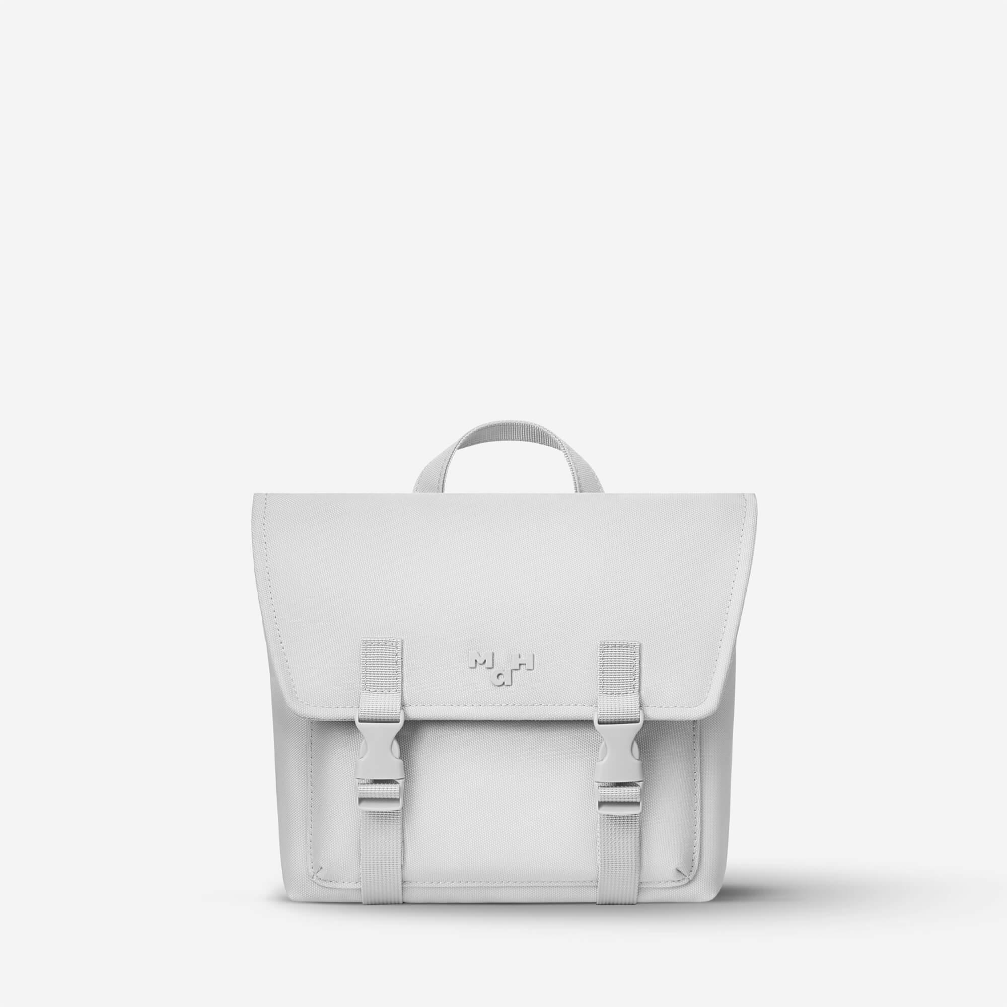 Minimalist white satchel bag with front flap, buckles, and top handle, ideal for everyday carry or school use.