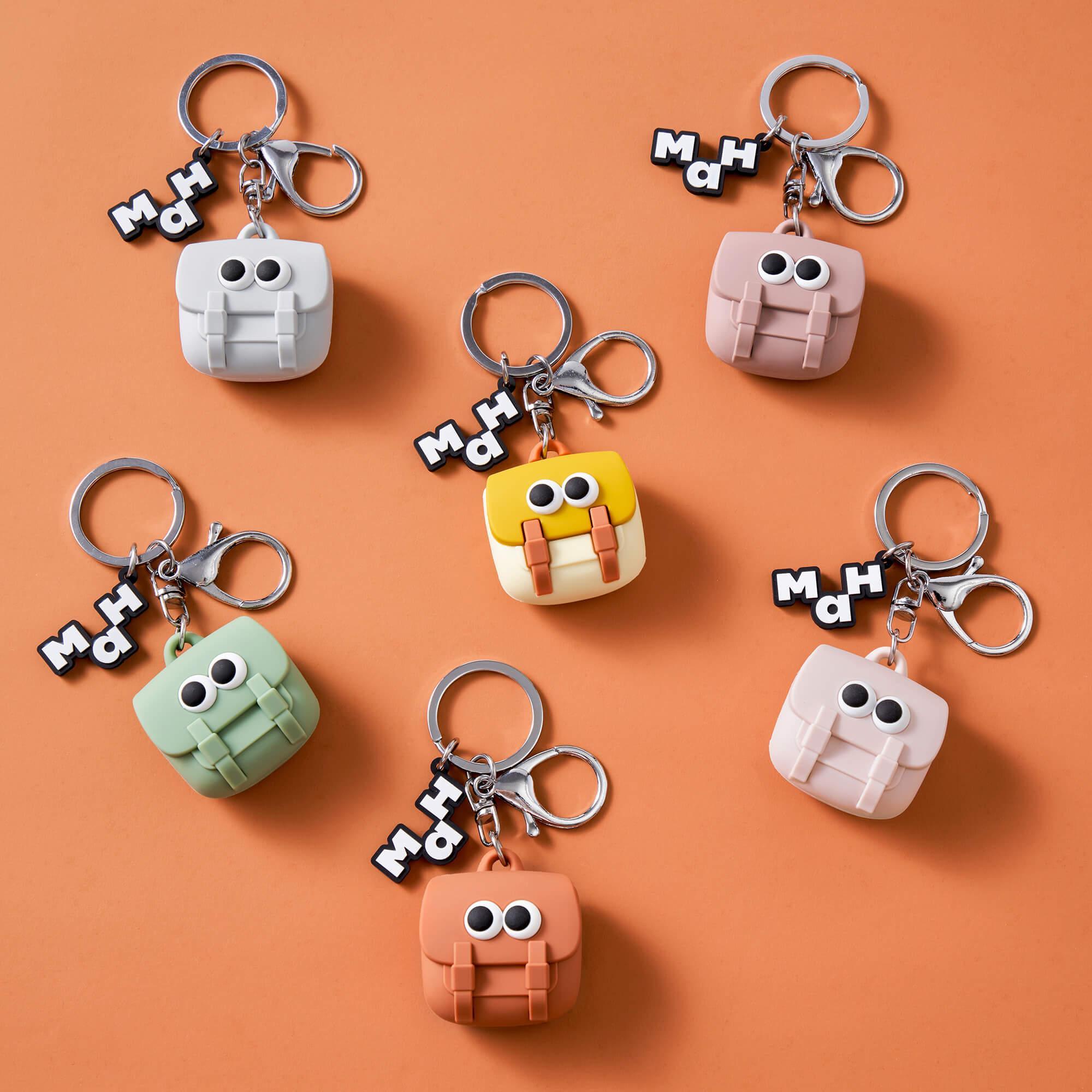 Cute backpack-shaped keychains with googly eyes in pastel colors, perfect for bags and accessories.