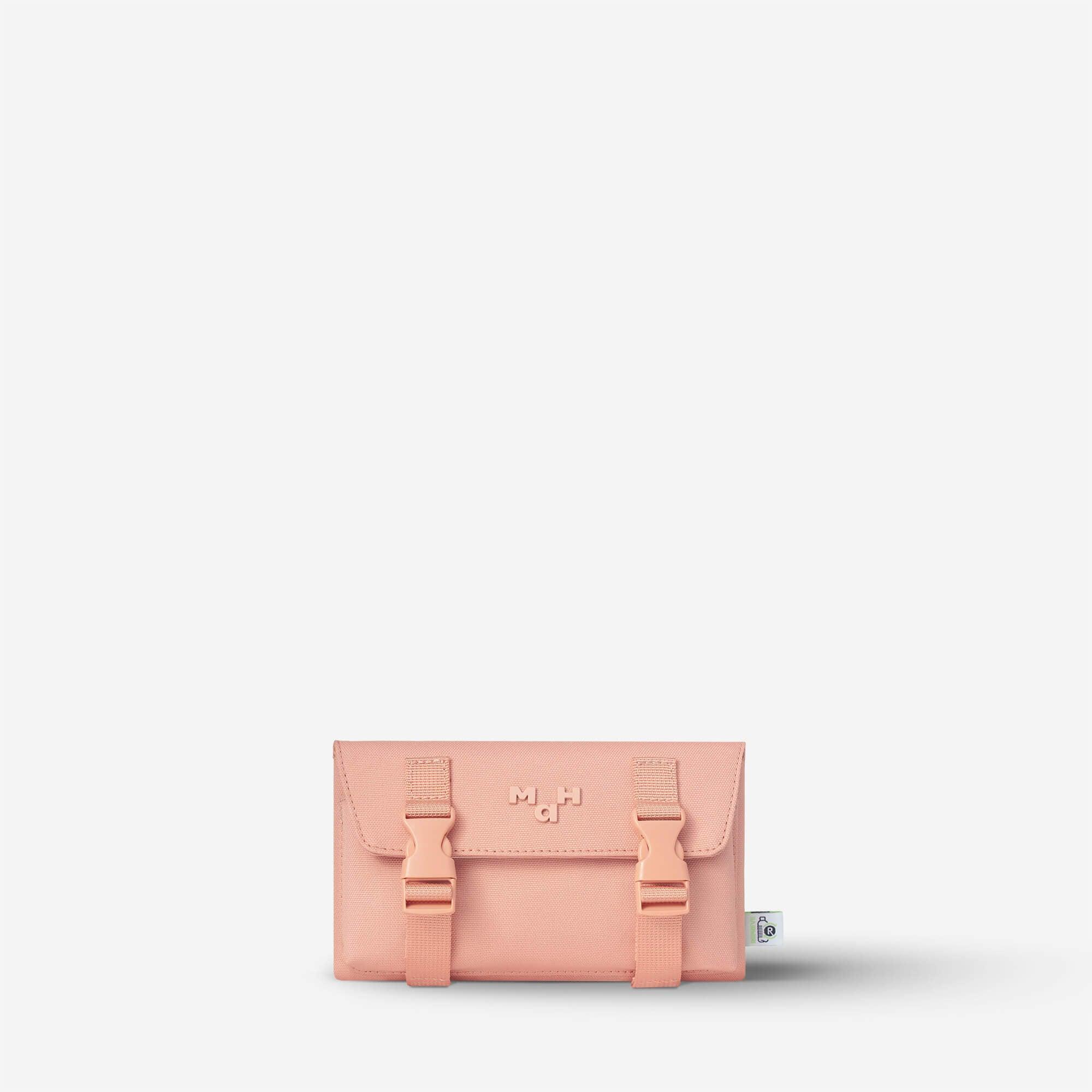 Pink minimalist wallet with buckle straps and recycled material tag, ideal for everyday carry
