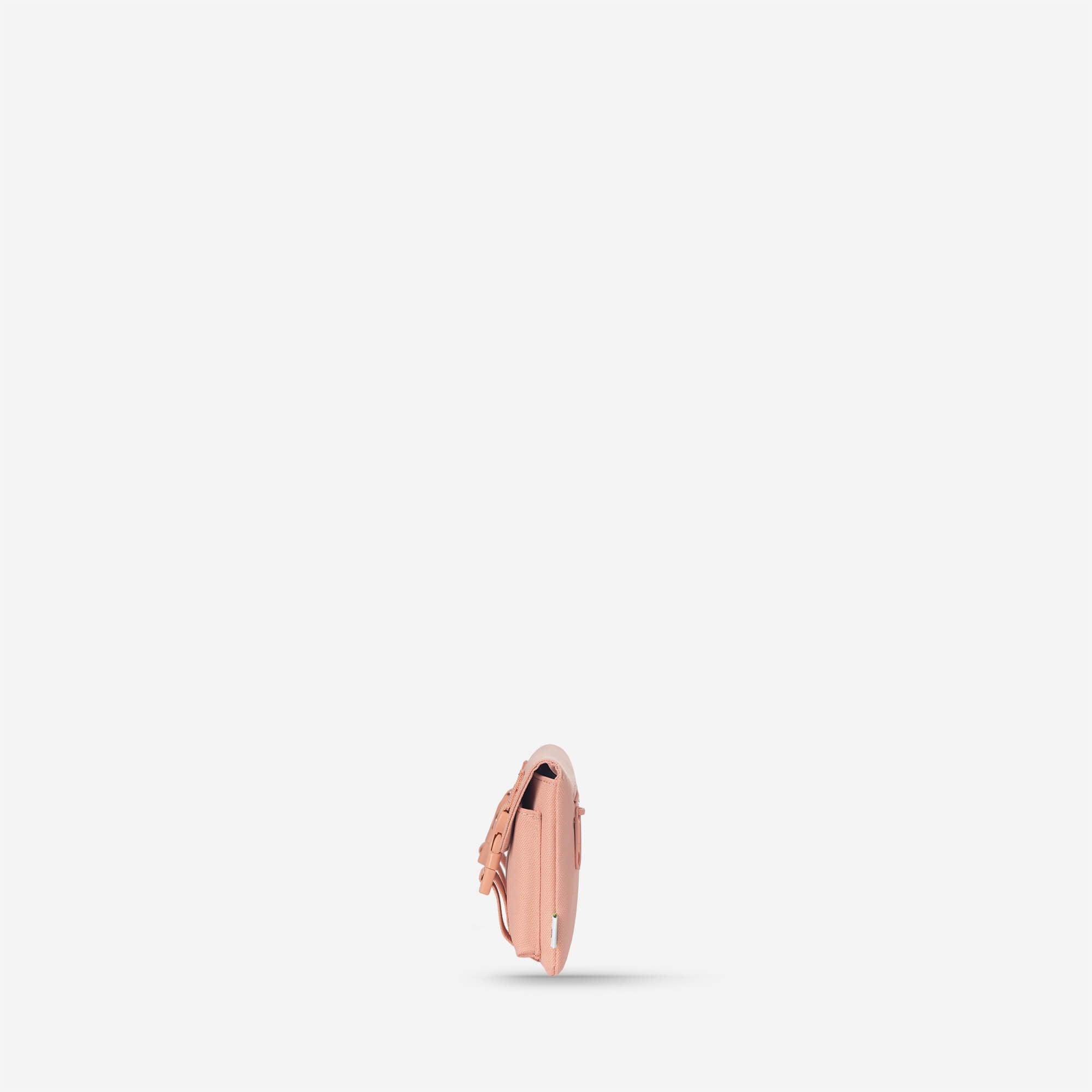 Pink compact crossbody bag with adjustable strap and side pocket, minimalist design for everyday use
