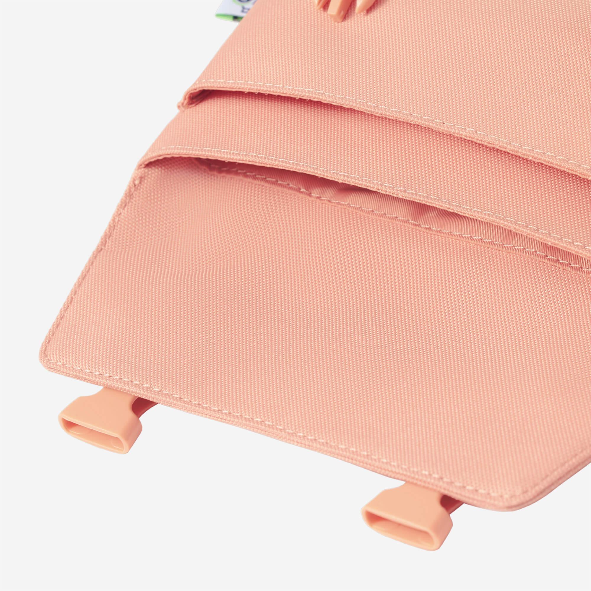 Soft pink backpack with textured fabric and matching plastic clips, ideal for everyday use