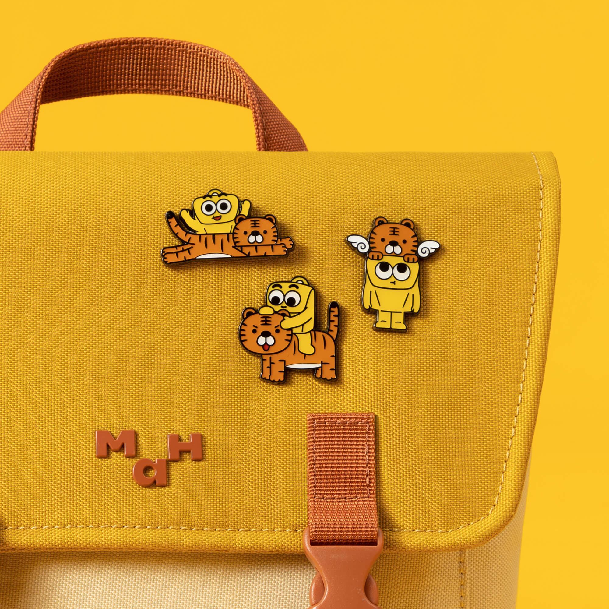 Yellow canvas bag with cute tiger and character enamel pins, playful design for everyday use