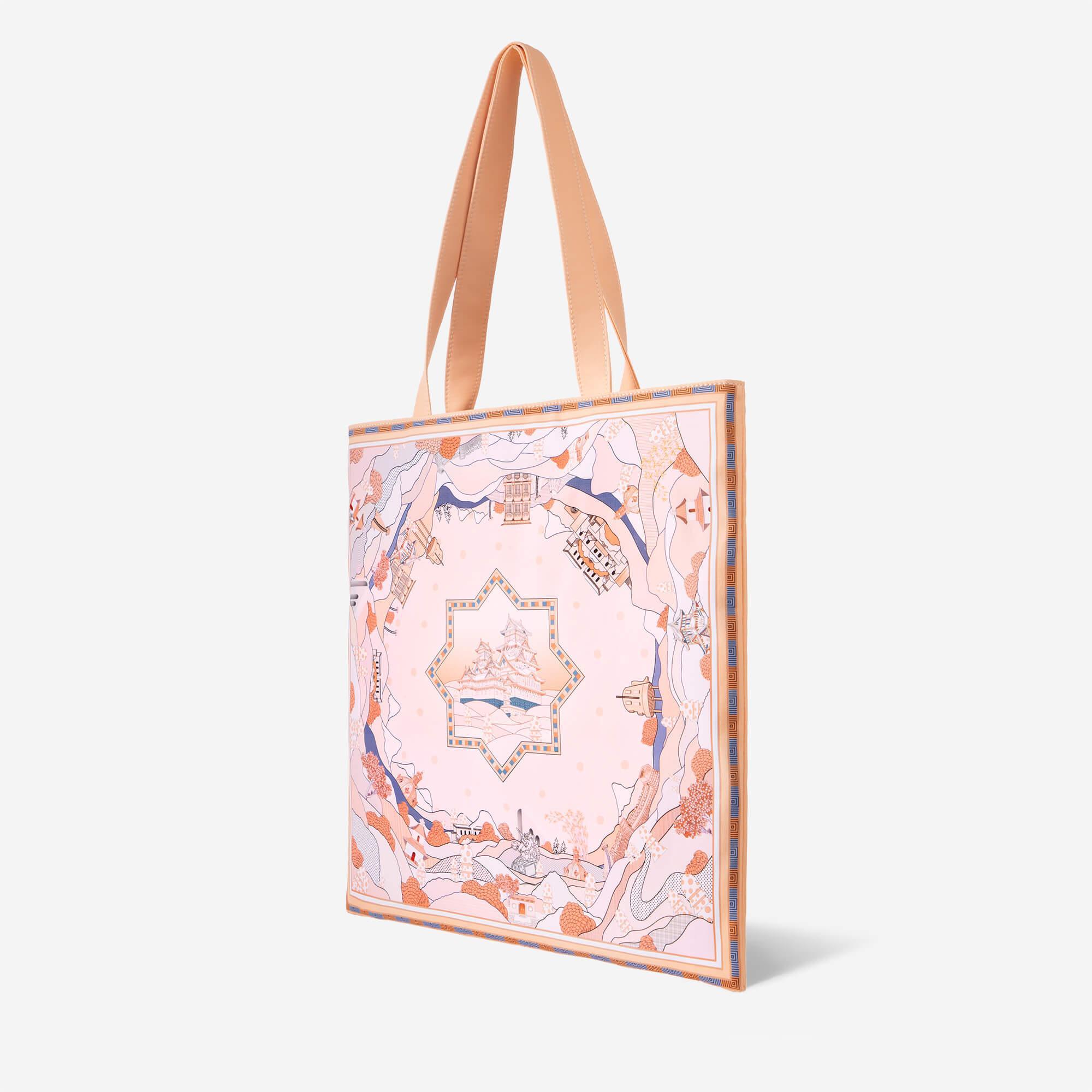 Pink tote bag with illustrated castle and landscape design, peach straps, stylish everyday accessory