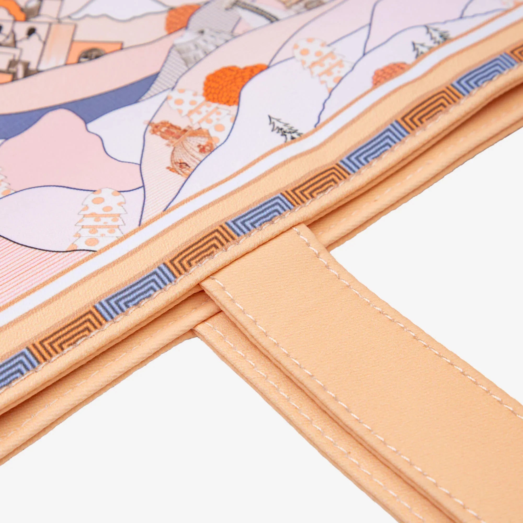 Close-up of a stylish bag with colorful abstract landscape print and geometric trim details