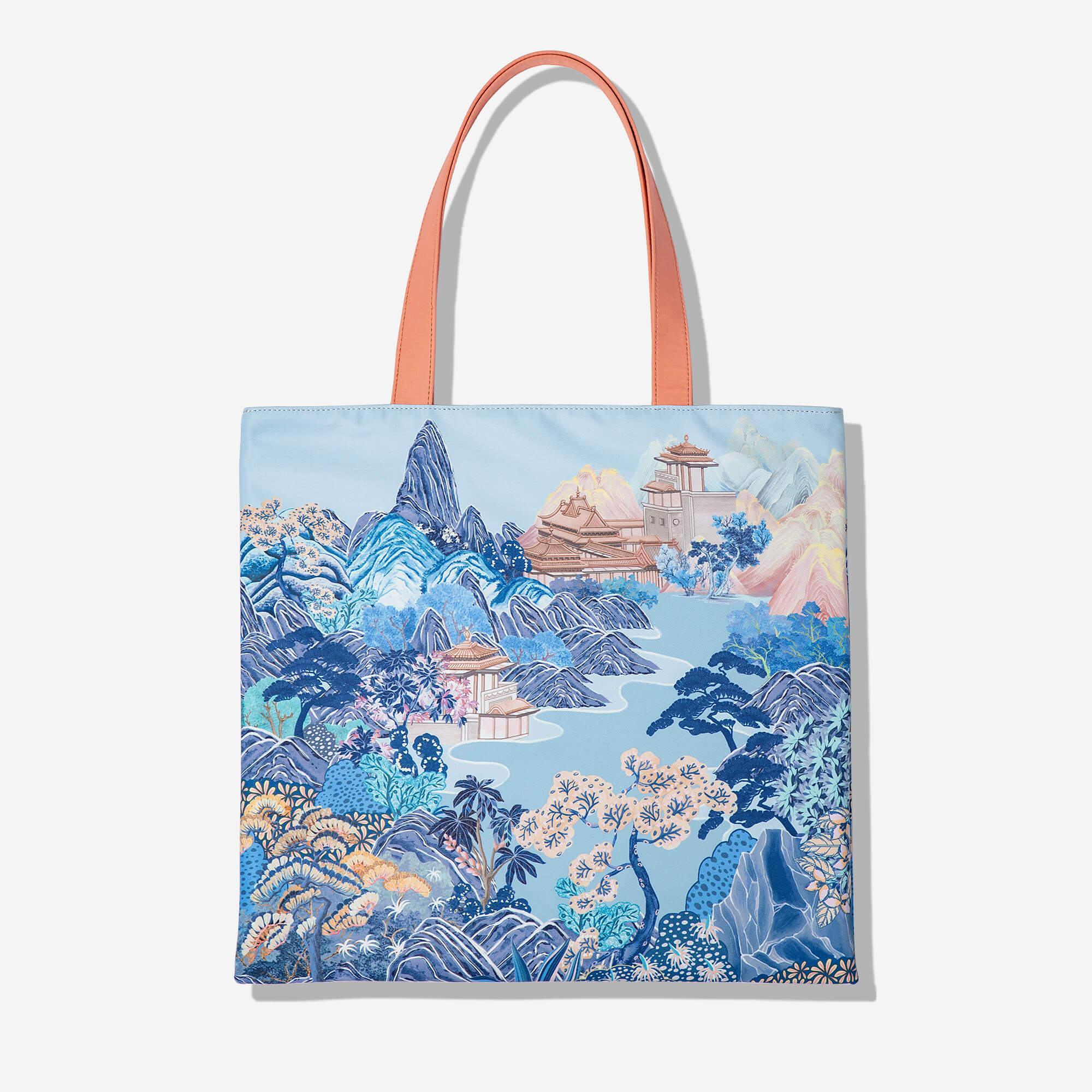 Tote bag with blue mountain landscape print, peach handles, and traditional pagoda design
