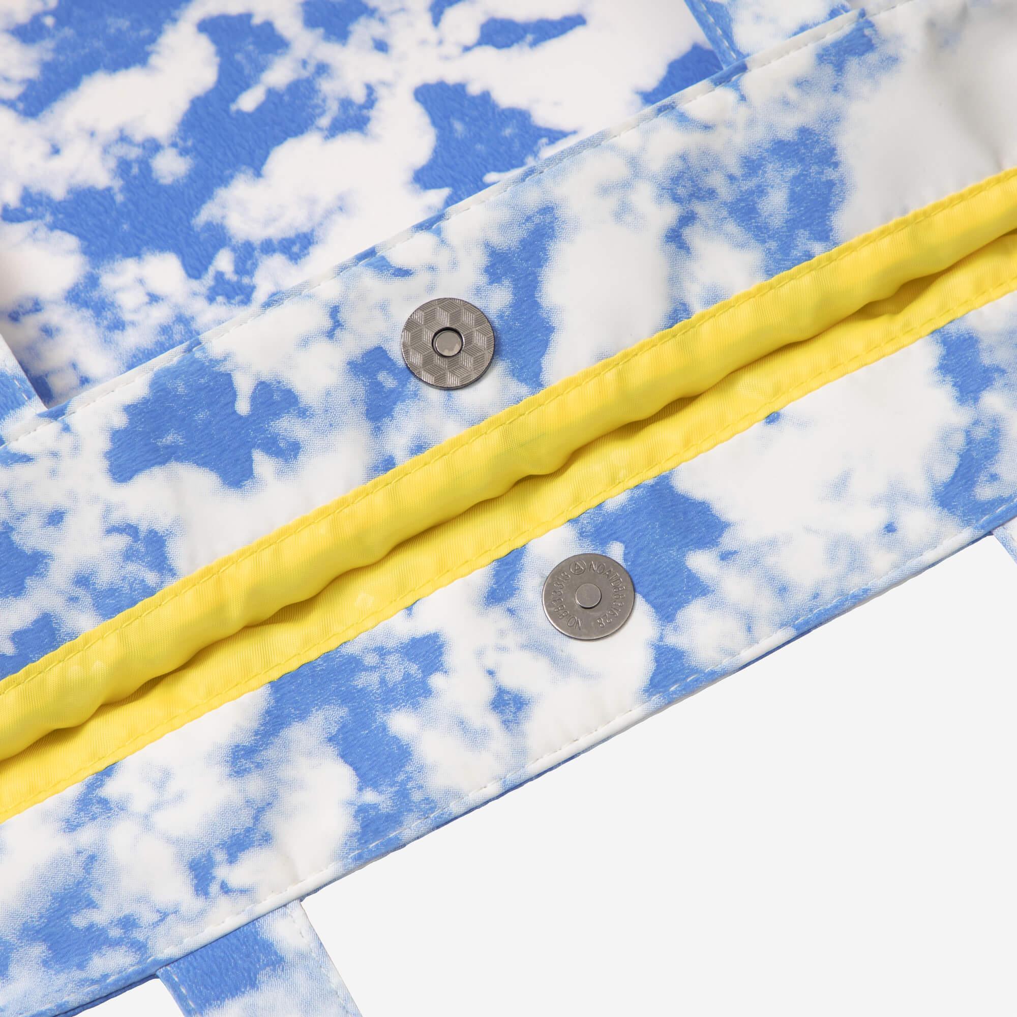 Blue sky cloud print bag with yellow trim and metal snap buttons