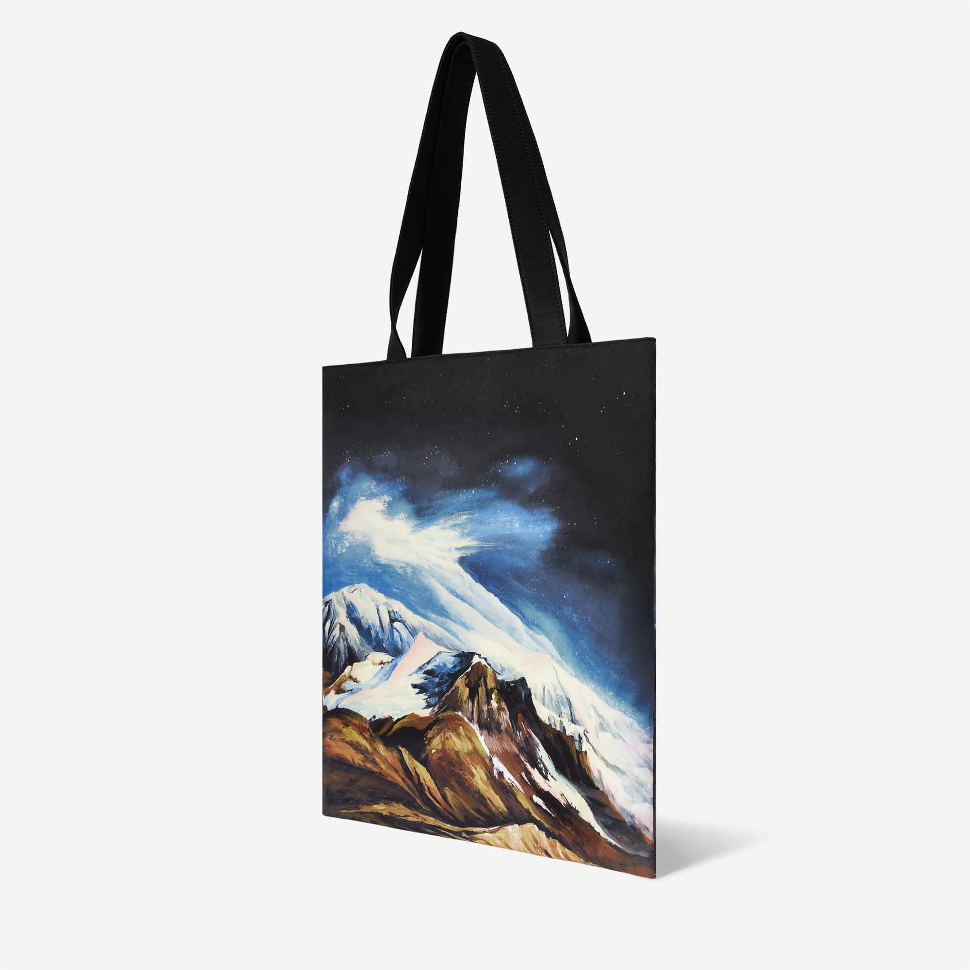 Tote bag with snowy mountain and starry sky print, black handles, stylish accessory for daily use