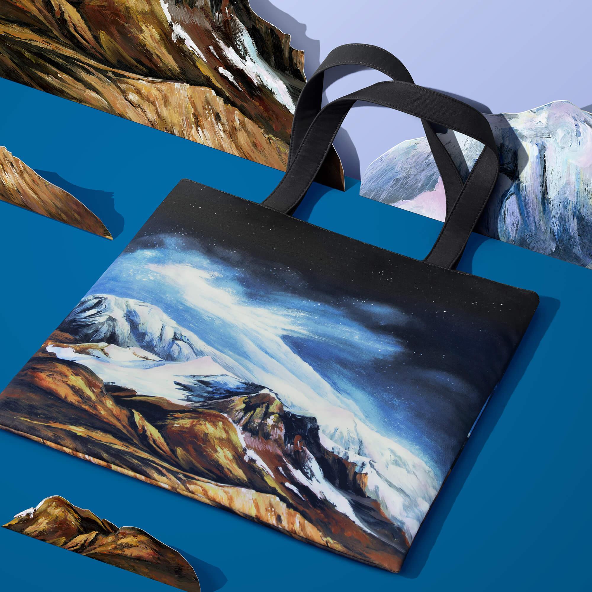 Tote bag with painted mountain landscape under starry sky, artistic travel accessory