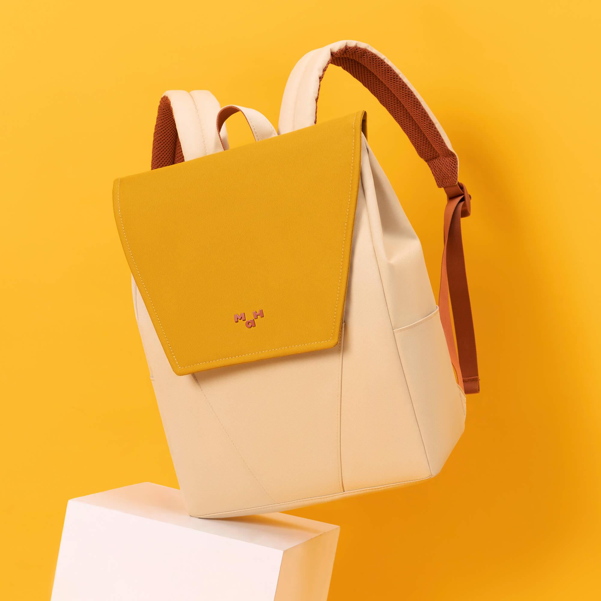 Stylish yellow and cream backpack with brown straps, modern design for everyday use