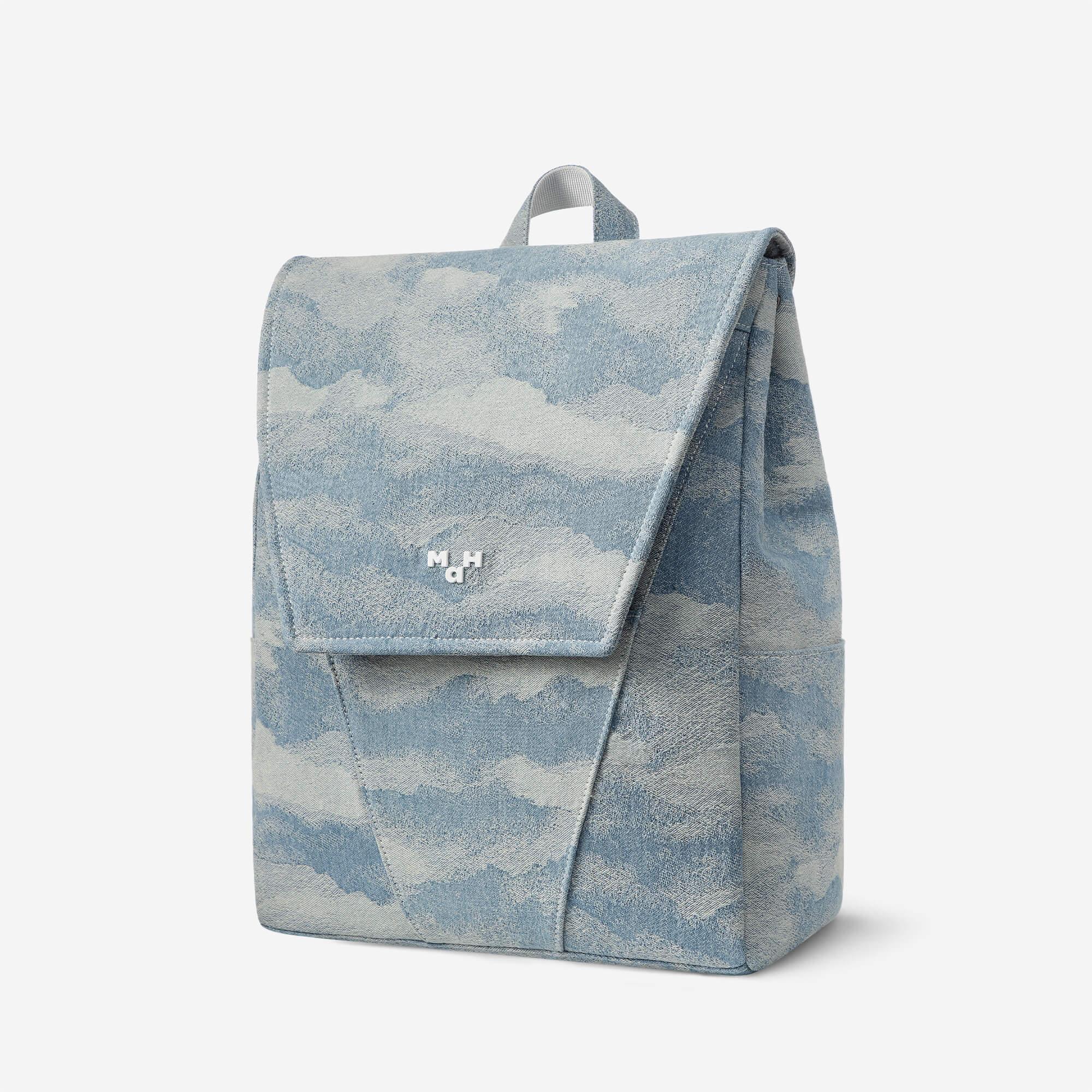 Light blue cloud-patterned backpack with front flap and top handle, ideal for everyday use