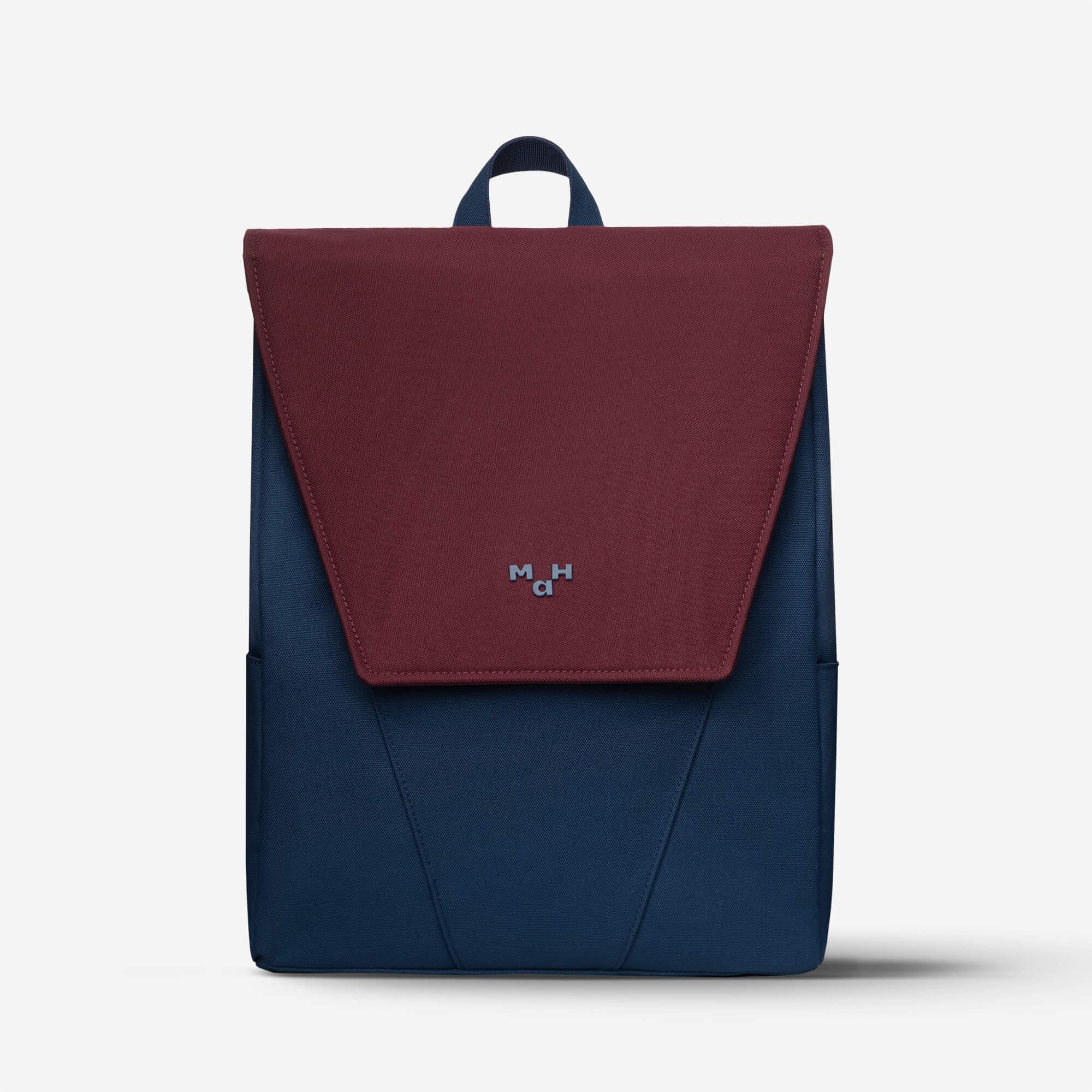 Maroon and navy blue backpack with flap closure and minimalist logo, ideal for daily use or travel.