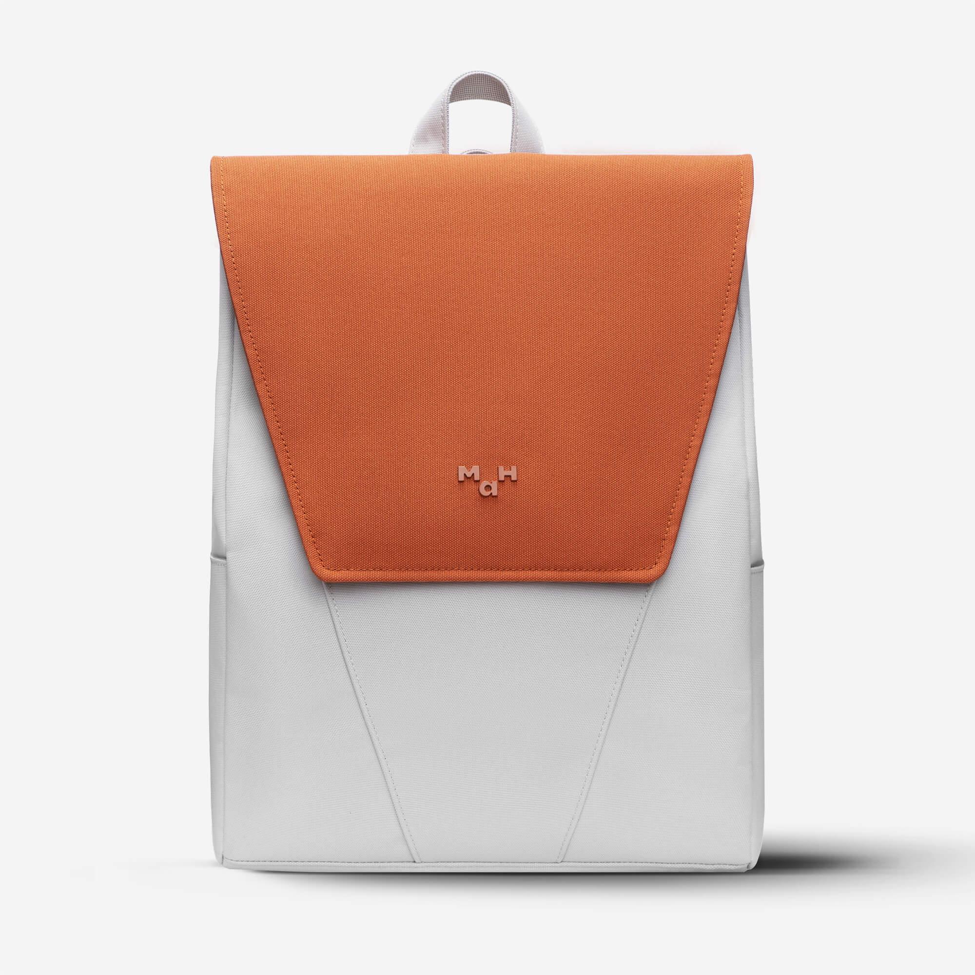 Modern two-tone backpack with orange flap and gray body, featuring minimalist design and top handle