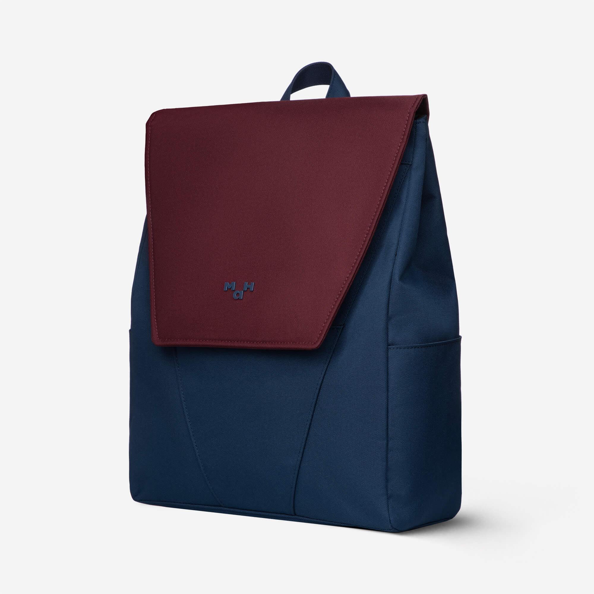 Navy blue and burgundy backpack with flap closure and subtle logo, ideal for daily use or travel.