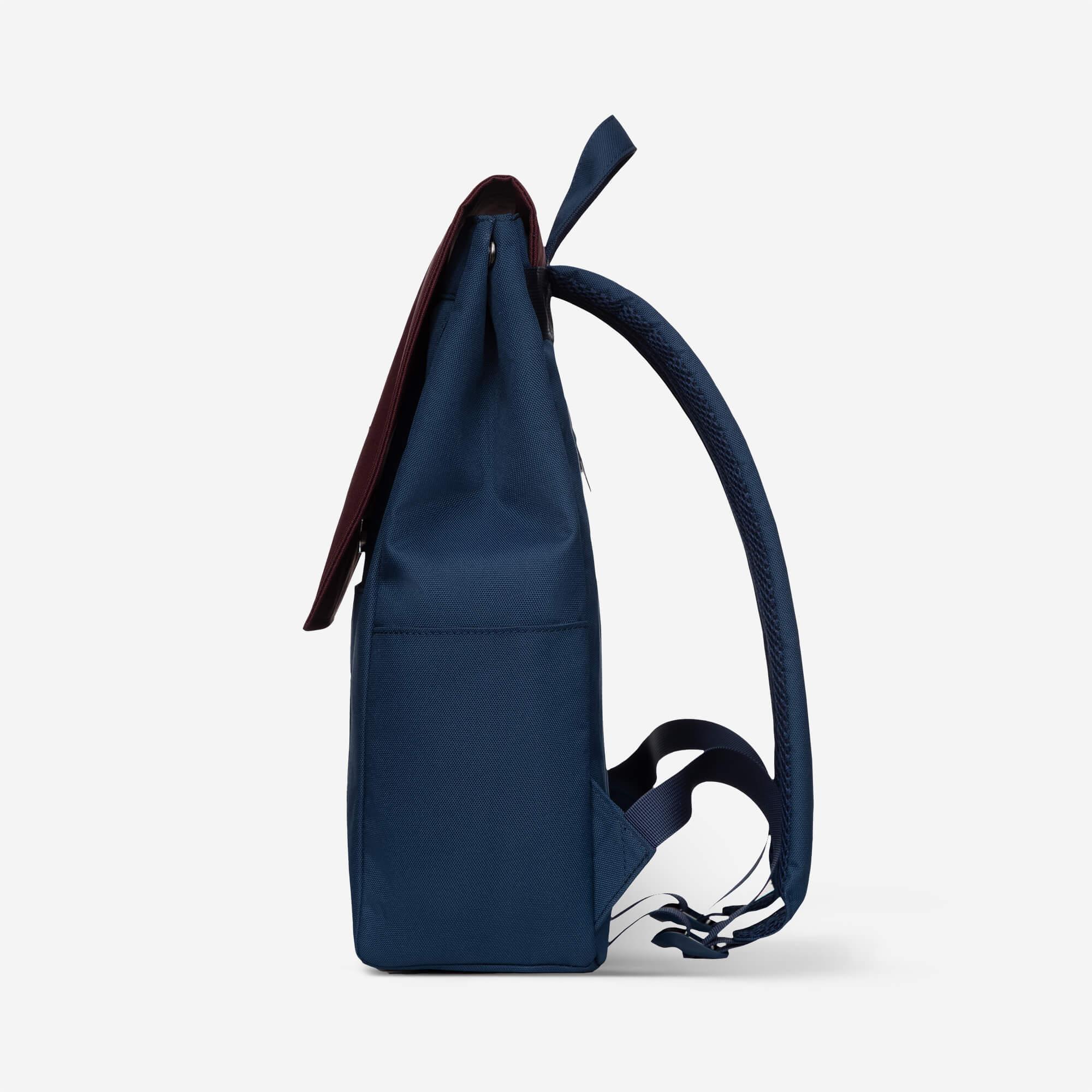 Navy blue backpack with burgundy accents and padded shoulder straps, ideal for daily use or travel.