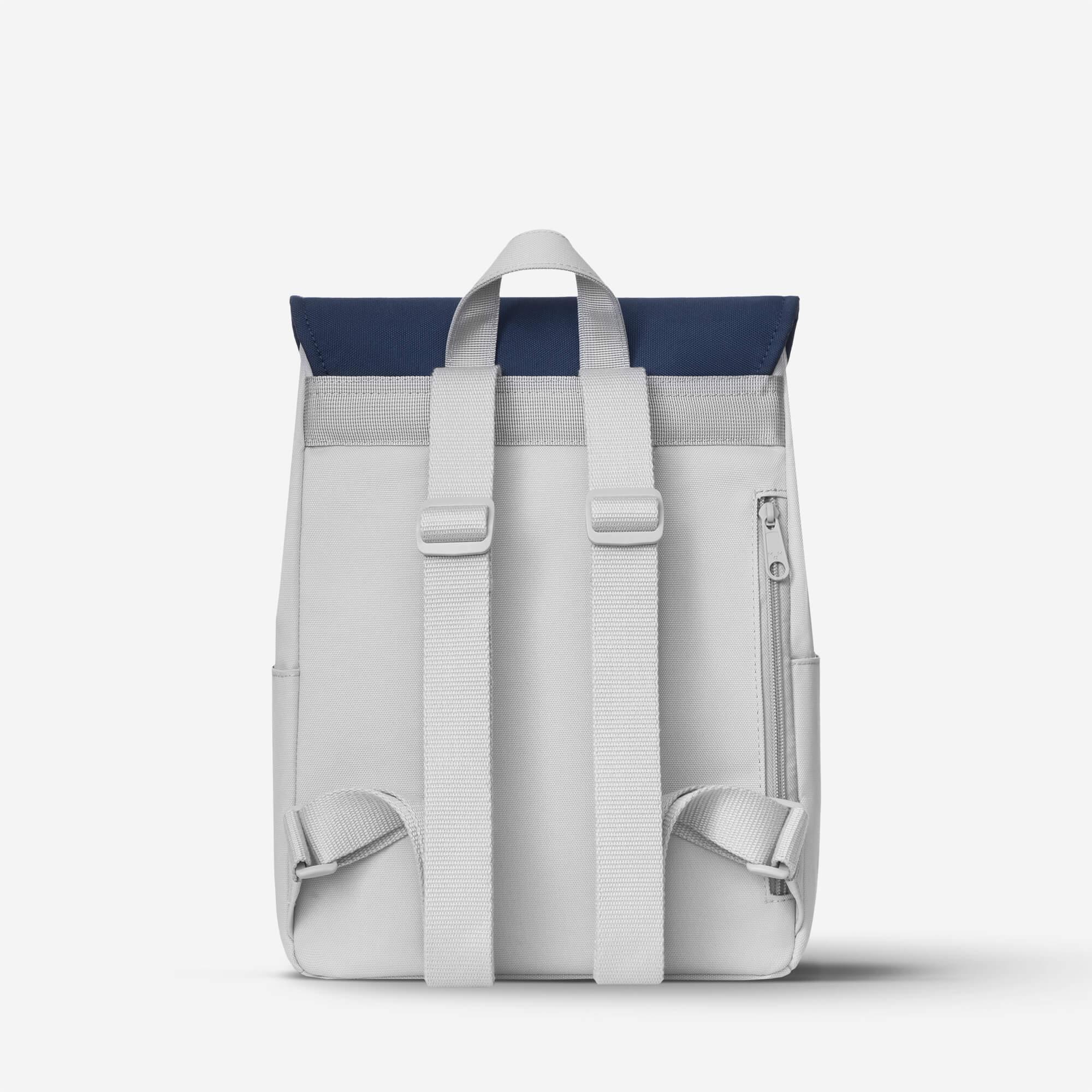 Light gray backpack with navy blue roll-top, adjustable straps, and side zipper pocket for daily use