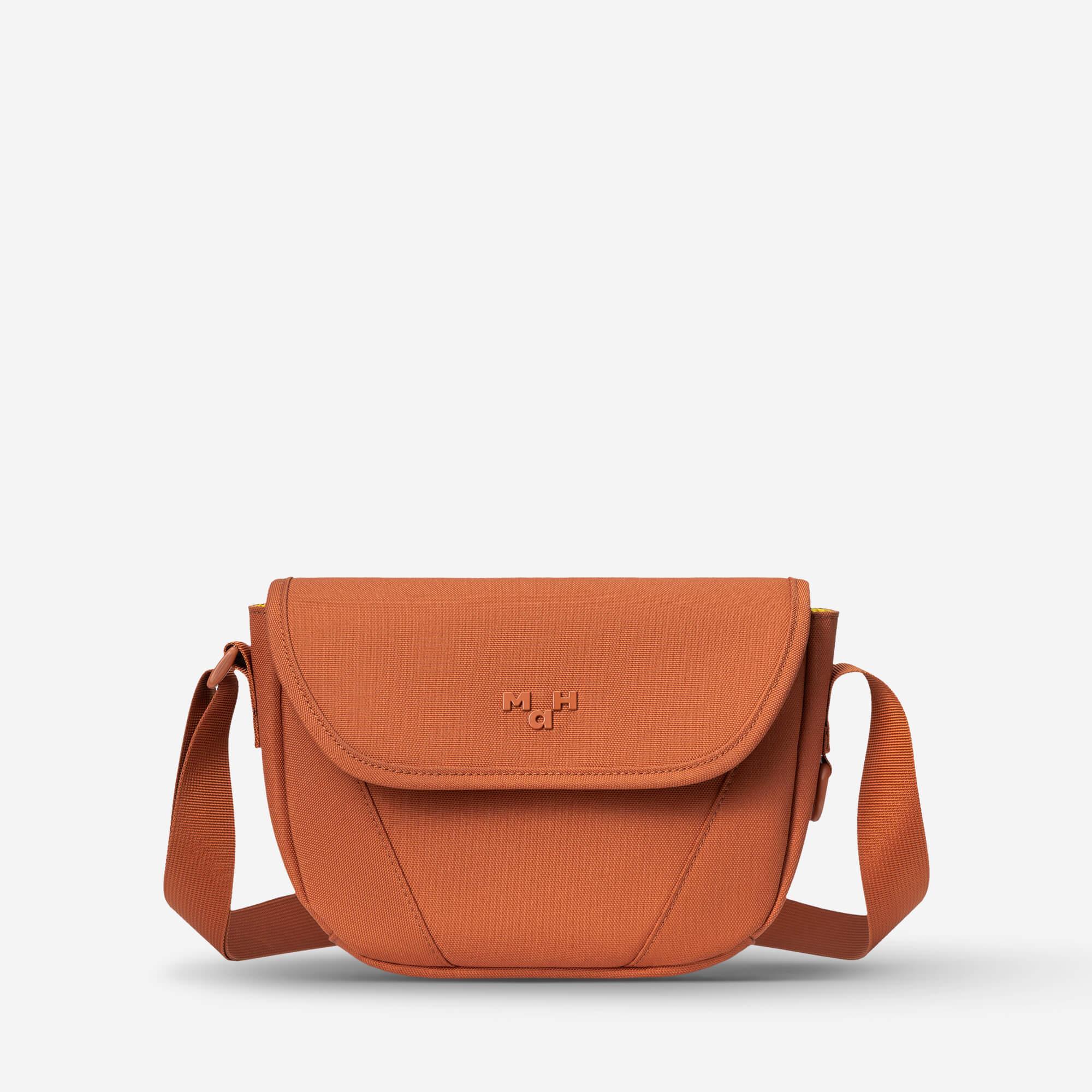 Rust orange crossbody bag with flap closure and adjustable strap, ideal for everyday use