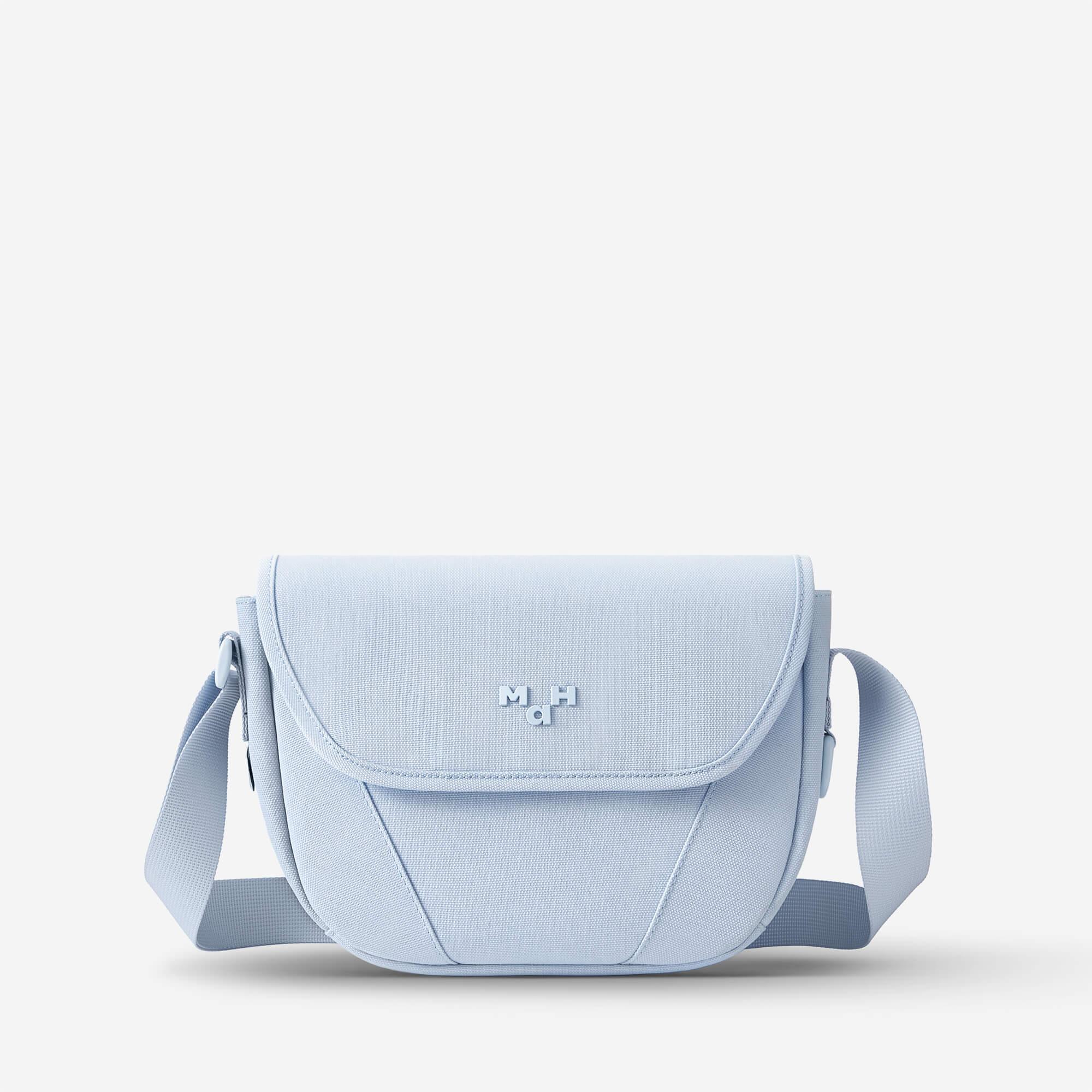 Light blue crossbody bag with adjustable strap and minimalist design, ideal for everyday use.