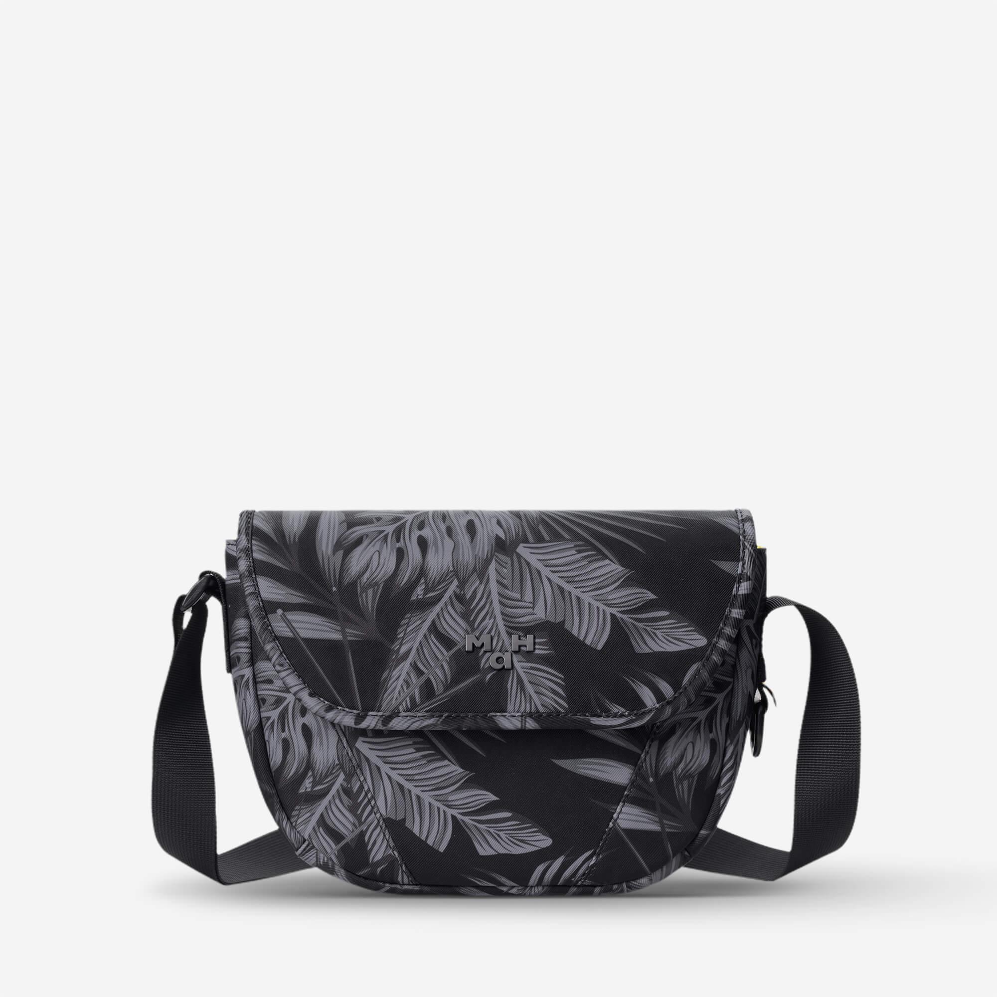 Black crossbody bag with gray leaf print, adjustable strap, and front flap closure