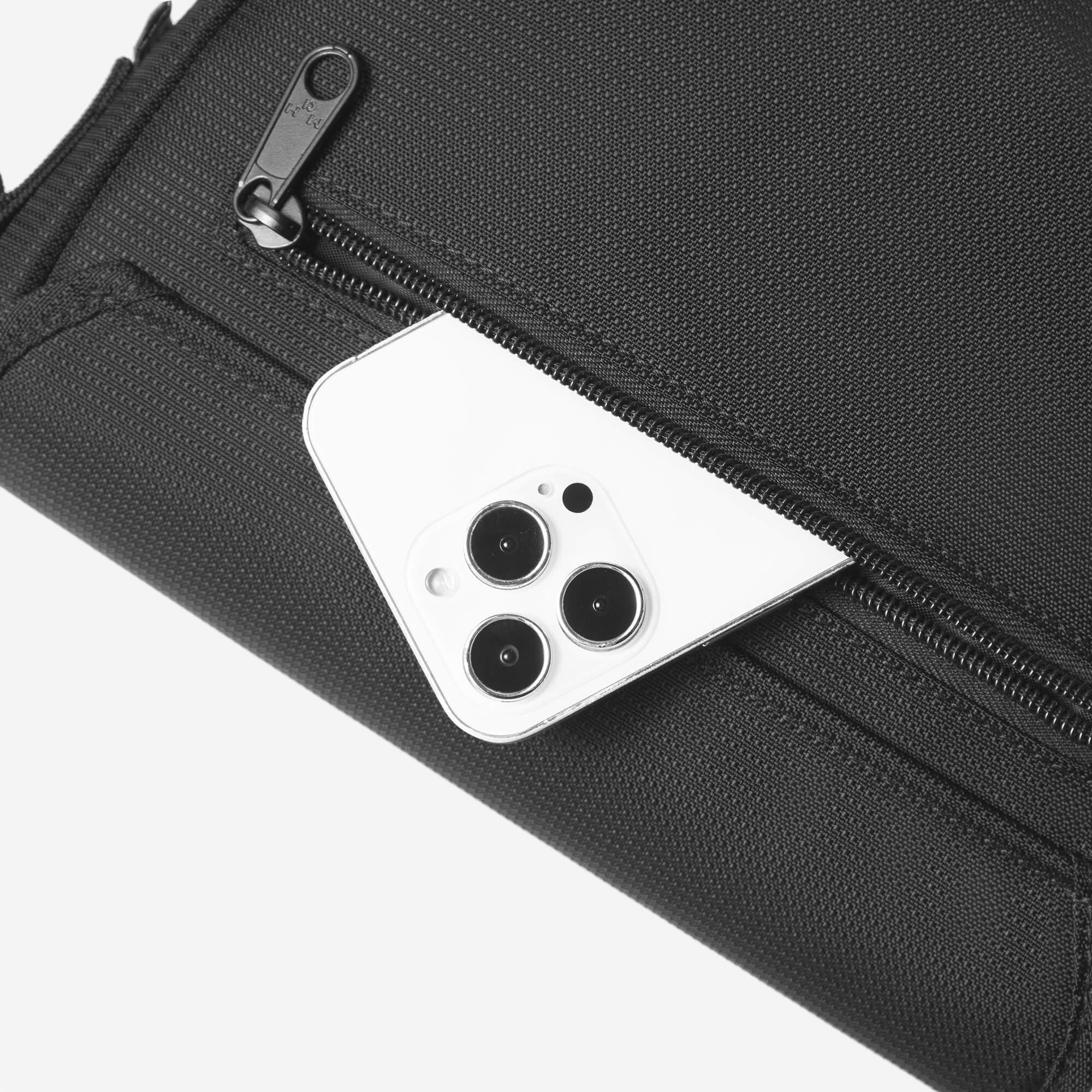 Black textured bag with zipper, holding white smartphone, ideal for travel or daily use