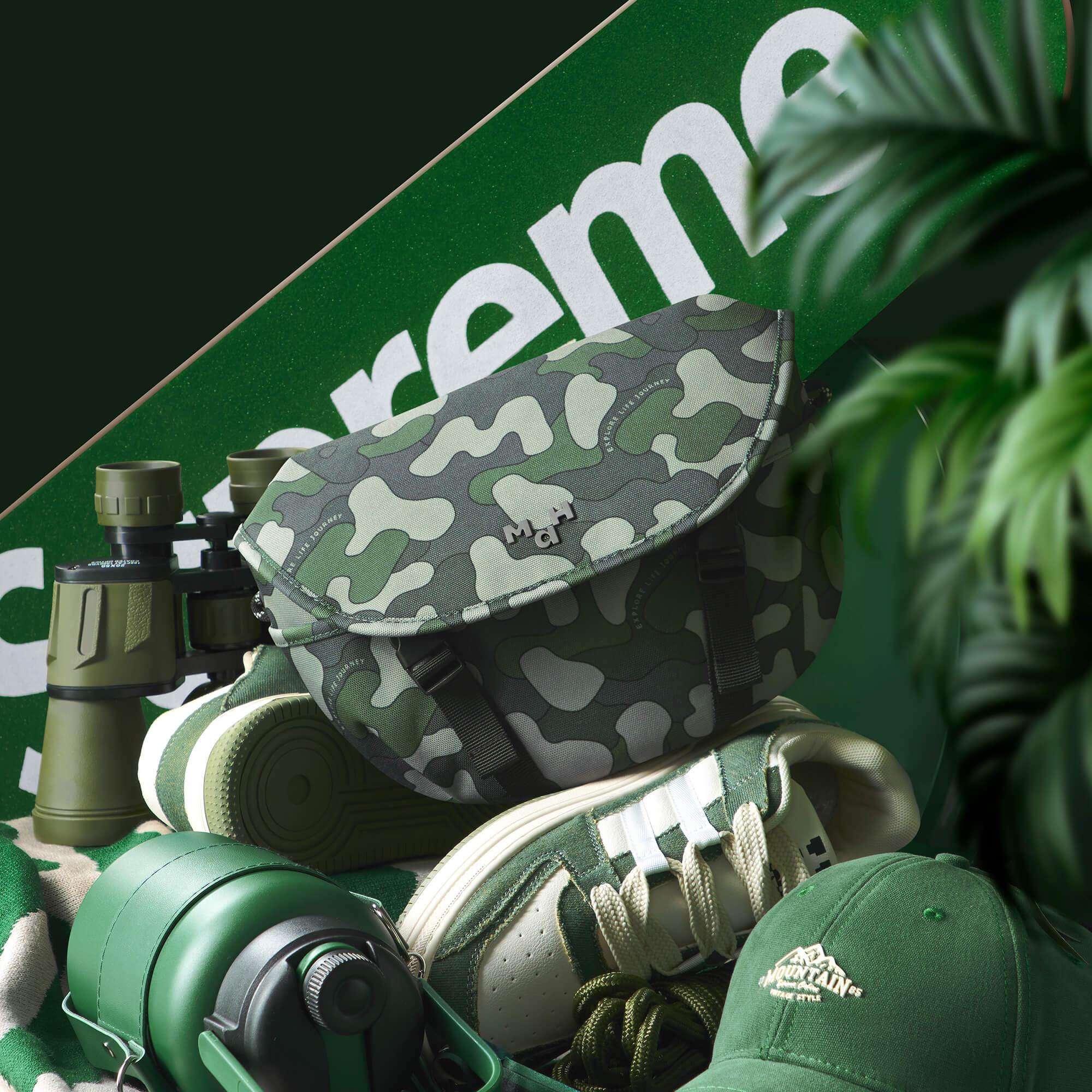 Camouflage sling bag with binoculars, green sneakers, and outdoor gear on green backdrop